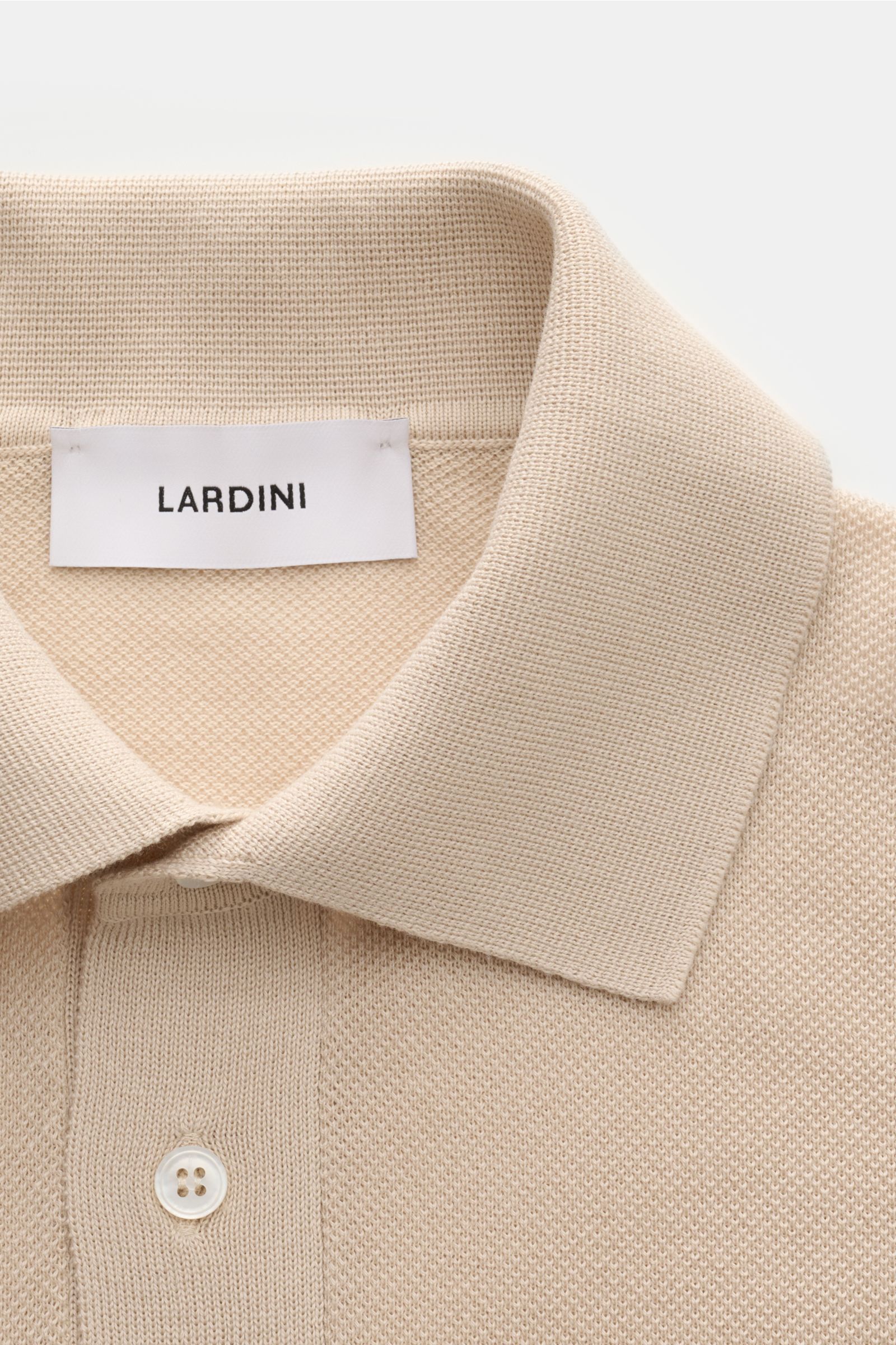 Lardini Kurzarm-Strickpolo beige in Slim Fit, reine Baumwolle, feines Piqué, Polokragen, Drei-Knopf-Leiste, Nahaufnahme von oben.