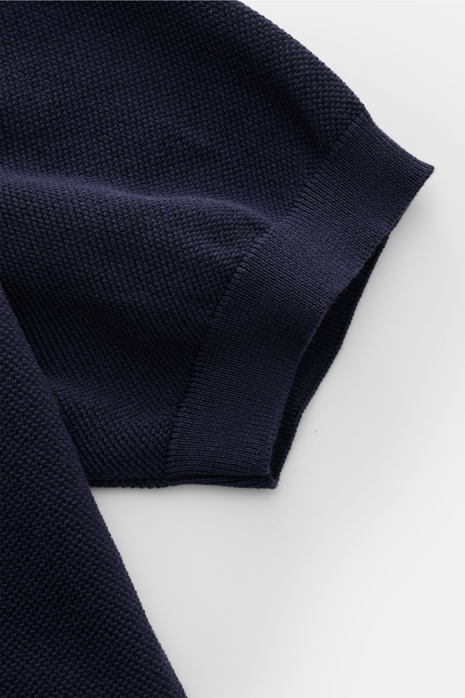 Close-up of the sleeve of the Lardini Kurzarm-Strickpolo navy, showcasing its fine piqué knit pattern and flexible ribbed cuff from a top-down perspective.

Ein Polo, das mehr kann als casual: LARDINI verleiht diesem Kurzarm-Strickpolo aus reiner Baumw