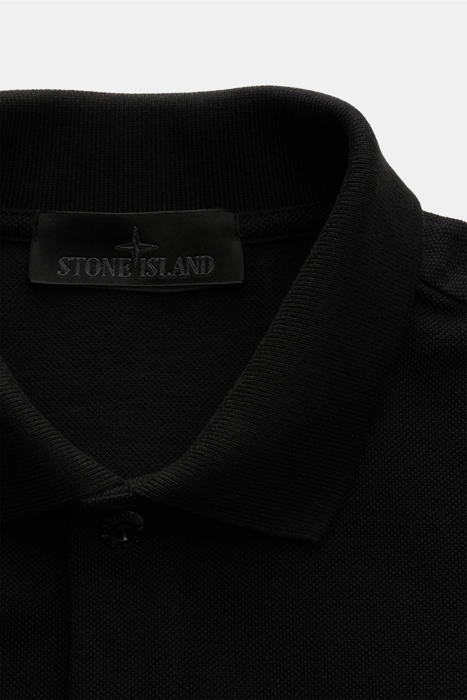 Stone Island Poloshirt 'Ghost Piece' schwarz, Slim Fit, reine Baumwolle, tonales Weblabel, Piqué, Polokragen, Knopfleiste, Nahaufnahme von oben.