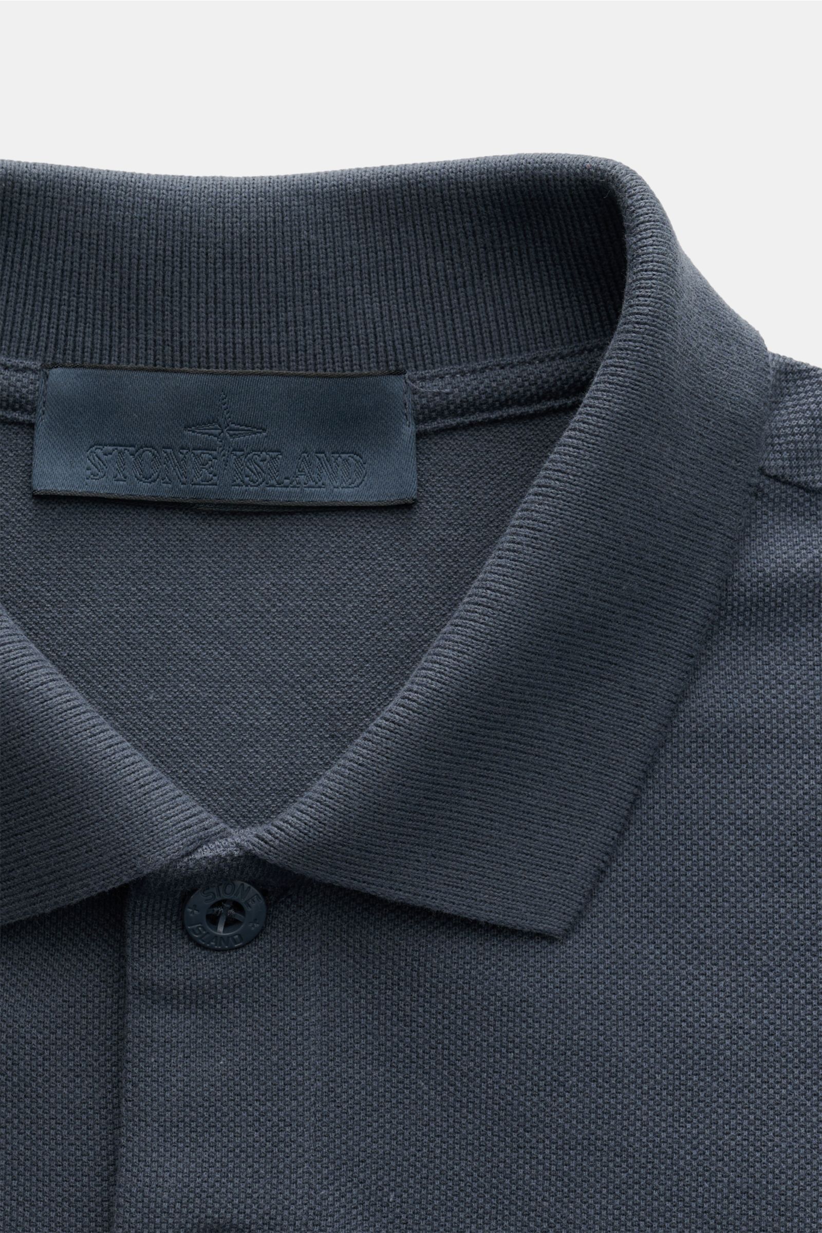 Stone Island Poloshirt 'Ghost Piece' graublau, Slim Fit, aus reiner Baumwolle, mit Polokragen und Zwei-Knopf-Leiste, Nahaufnahme von oben.