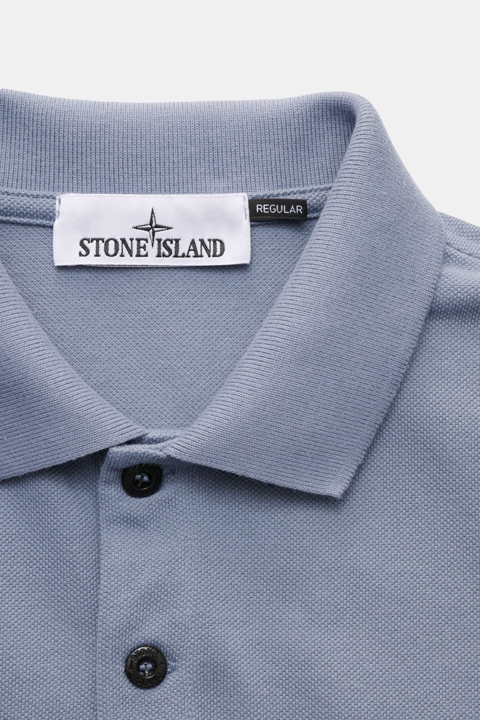 Stone Island Poloshirt rauchblau aus Baumwoll-Piqué, Slim Fit, Polokragen, glatte Knopfleiste, flexible Ärmelbündchen, Detailaufnahme von oben.