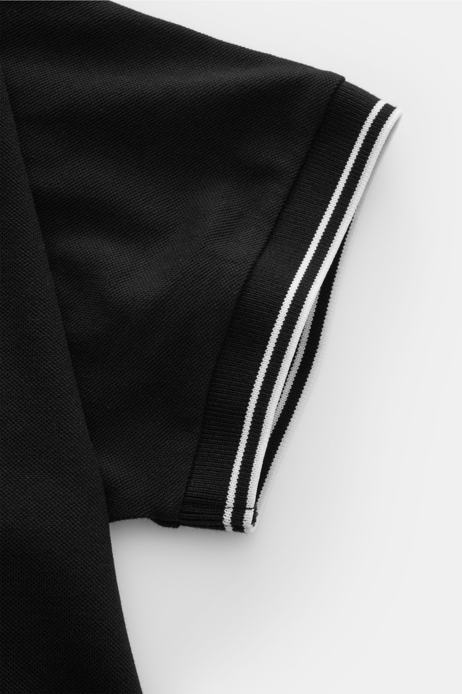 Stone Island Poloshirt schwarz, Nahaufnahme Ärmelsaum mit schmalen weißen Kontraststreifen, elastische Baumwolle, Slim Fit, Piqué-Struktur.