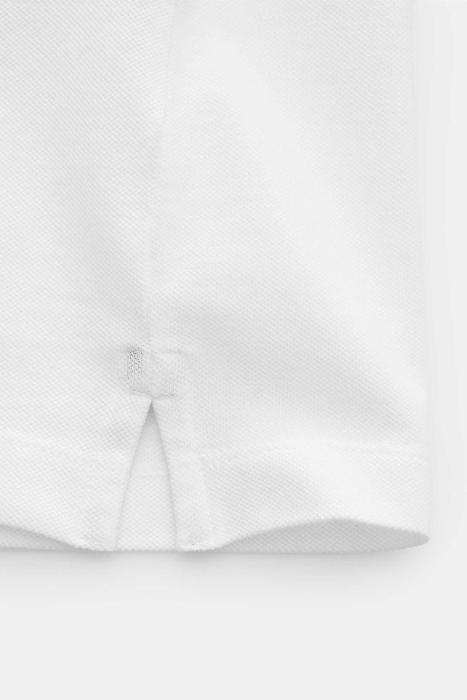 Weißer Nahaufnahme-Ausschnitt des Stone Island Poloshirts weiß mit elastischem Baumwoll-Piqué, schmalen Saumschlitzen und weichem Griff aus Slim Fit Perspektive.