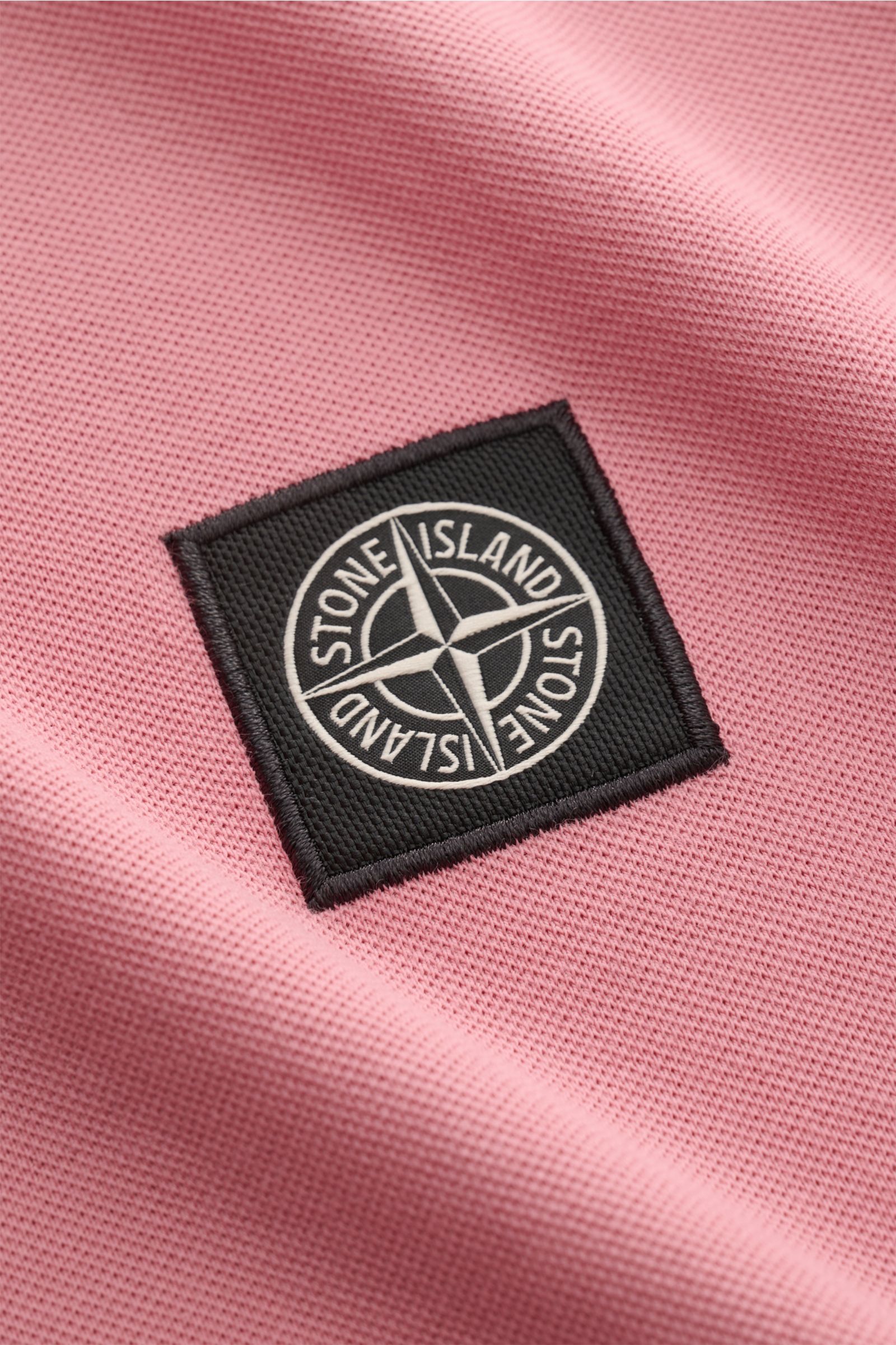 Stone Island Poloshirt rosé in Nahaufnahme, Piqué-Baumwolle mit weichem Griff, elastischen Bündchen, schmalen Kontraststreifen und Weblabel.