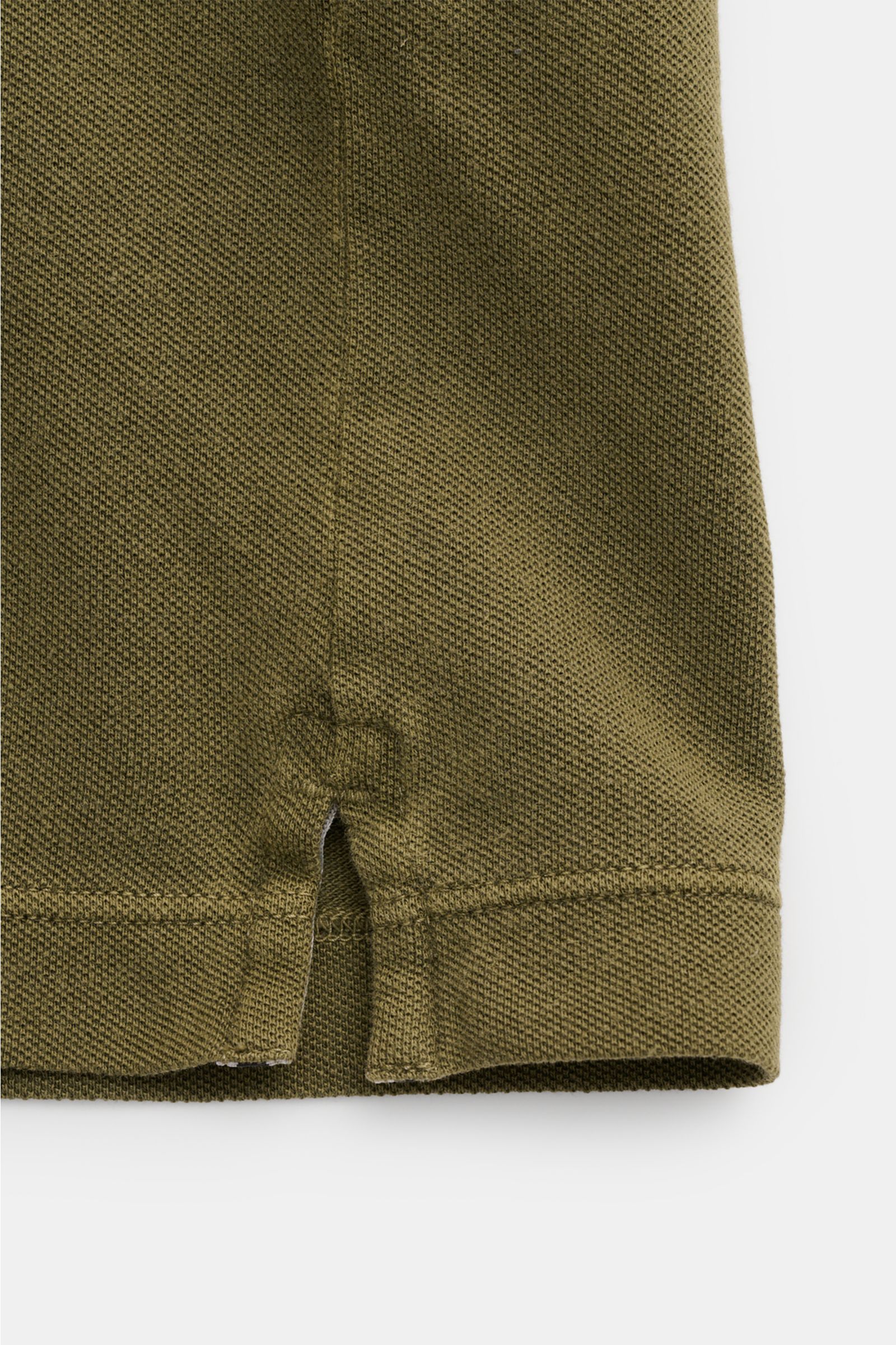 Stone Island Poloshirt oliv aus Baumwoll-Piqué, Slim Fit, seitliche Saumschlitze, Detailaufnahme vom unteren Saum mit strukturierter Oberfläche.