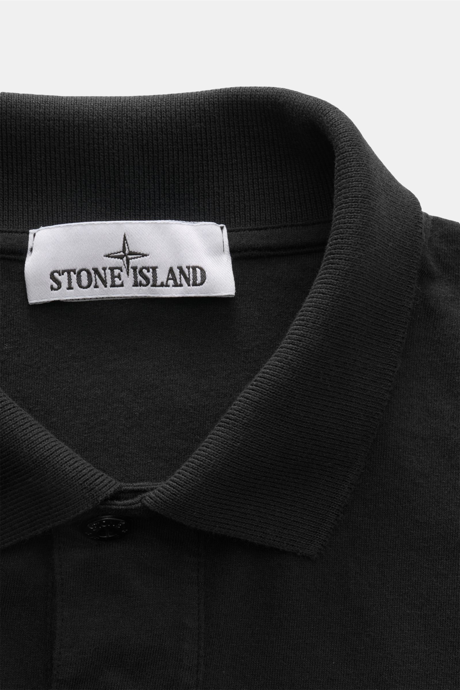 Close-up front view of Stone Island Jersey polo shirt black collar and label, made of soft pure cotton jersey in slim fit.

Description: This lightweight polo shirt is a must-have for sporty men’s wardrobes: Made of cotton jersey, this timeless model b
