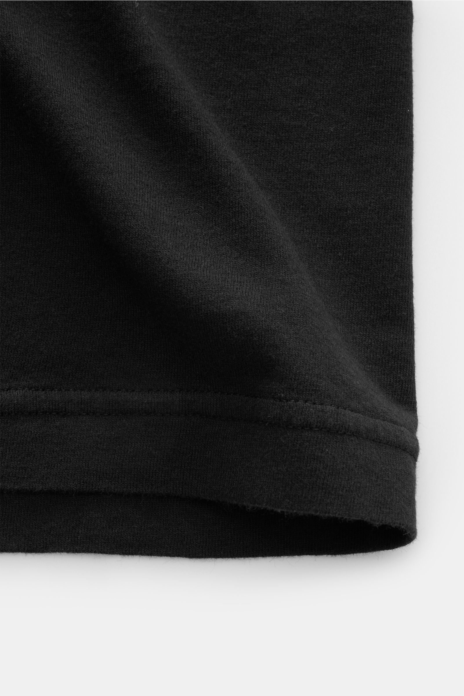 Close-up front view of the hem of the Stone Island Jersey polo shirt black showing fine cotton jersey fabric texture and stitching details.

This lightweight polo shirt is a must-have for sporty men’s wardrobes: Made of cotton jersey, this timeless model 