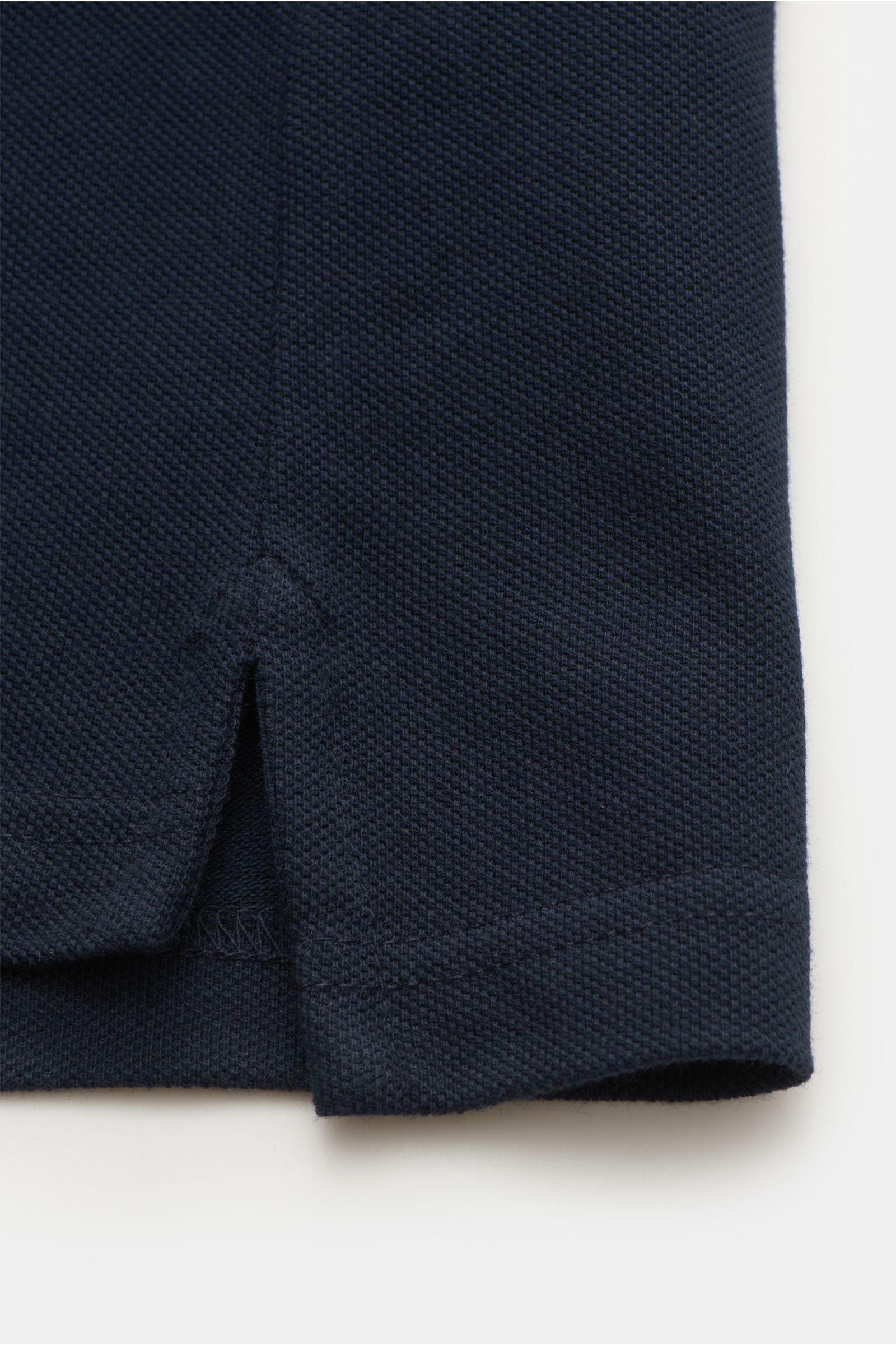 Nahaufnahme des seitlichen Saums mit Saumschlitz des Belstaff Poloshirts navy aus Piqué-Baumwolle, leicht strukturierter Griff sichtbar, Slim Fit.