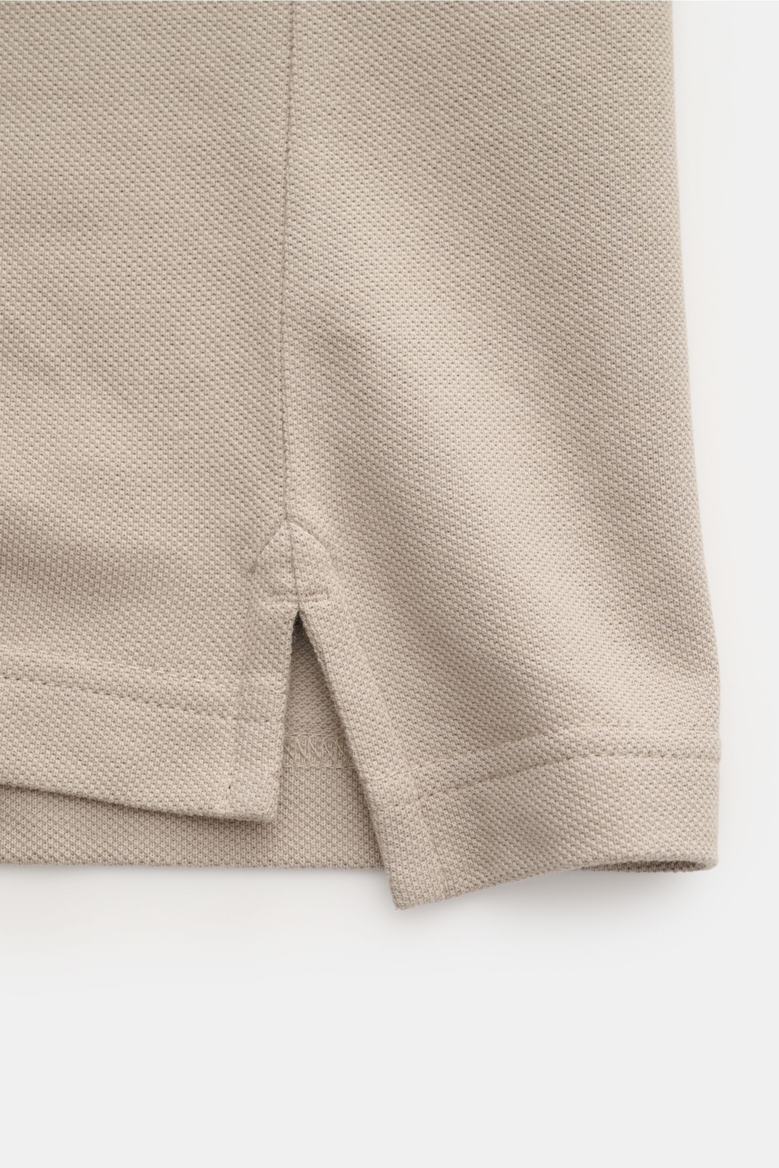 Belstaff Poloshirt taupe, Detailaufnahme der seitlichen Saumschlitze, Piqué aus reiner Baumwolle, Slim Fit, klassischer Polokragen, BELSTAFF-Weblabel.