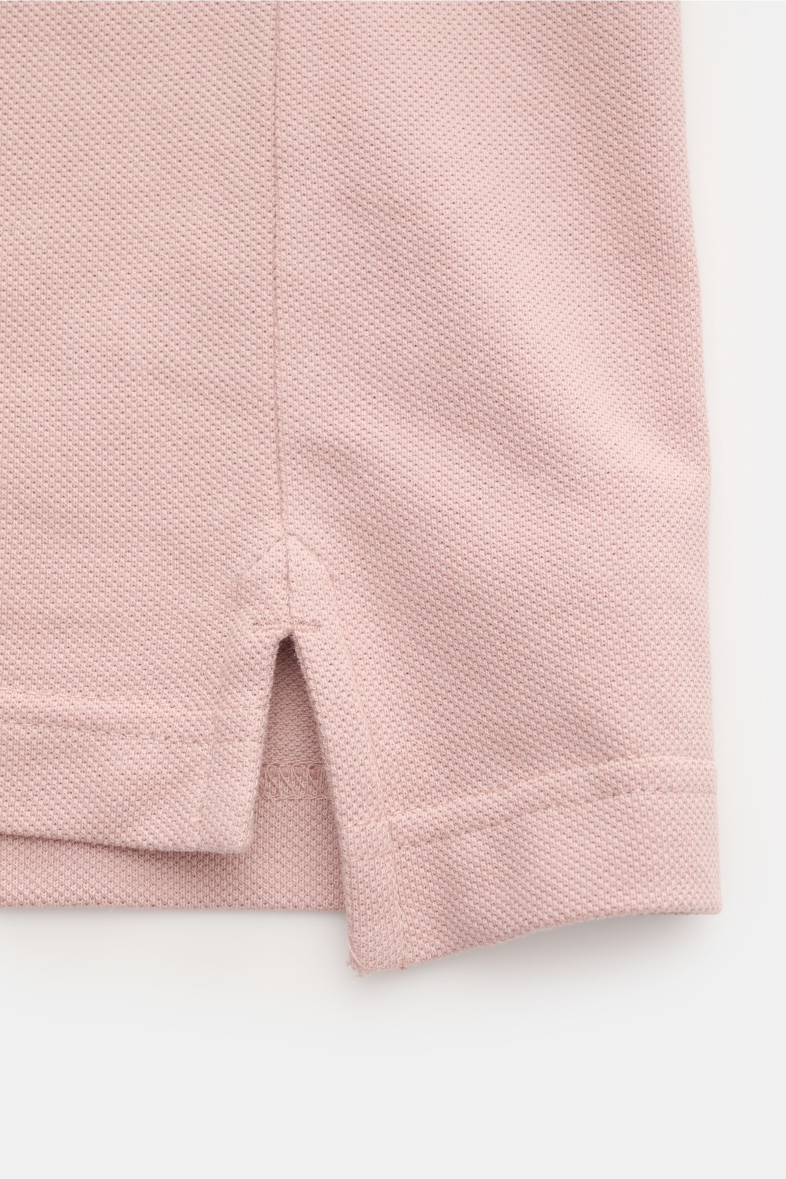 Detailaufnahme des unteren Saumbereichs vom Belstaff Poloshirt altrosa, Piqué-Baumwolle, leicht strukturierter Griff, Slim Fit, seitliche Saumschlitze.