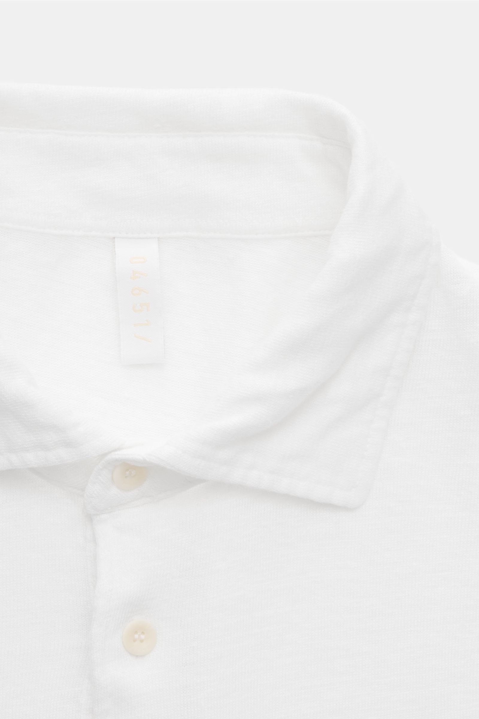 Nahaufnahme von Kragen und Knopfleiste des weißen 04651/ A trip in a bag Leinen Jersey-Poloshirts in Slim Fit, elastisch und stückgefärbt.
