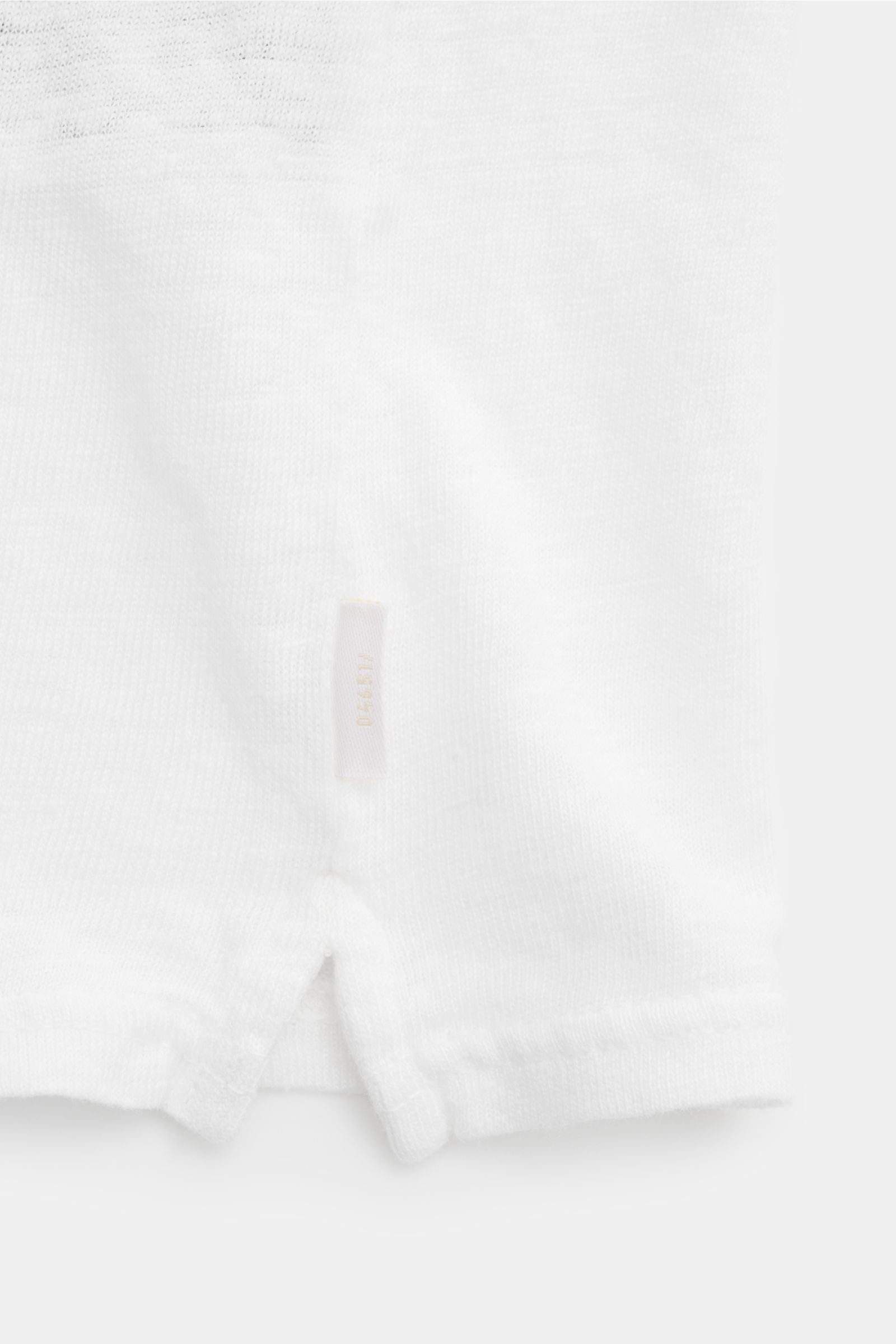 Weißes 04651/ A trip in a bag Leinen Jersey-Poloshirt, Detailaufnahme der kurzen Saumschlitze und kleinem Weblabel, elastisch und slim fit.