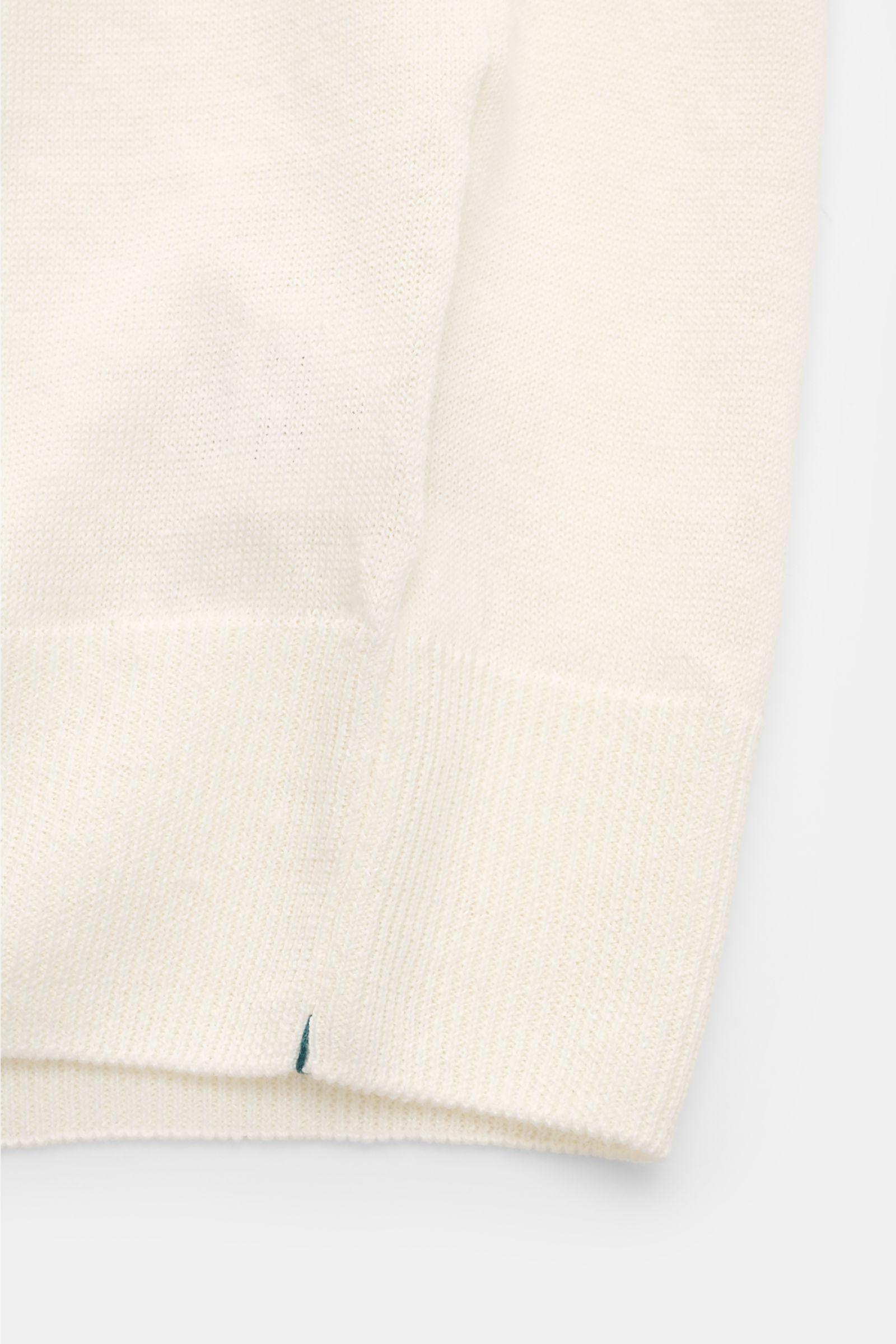 Close-up front view of the hem and side seam of the Fioroni Short sleeve knit polo cream, showing its fine, airy knit in a linen and cotton blend with flexible ribbed bands. Summery luxury: This short-sleeved knit polo by FIORONI embodies the finest Itali