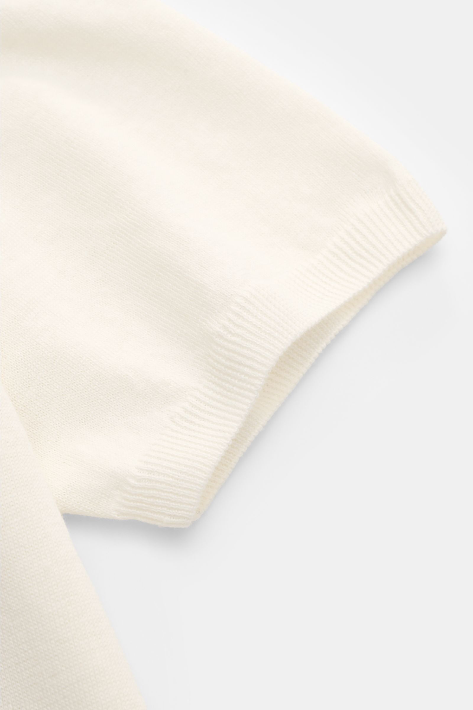 Close-up view of the sleeve hem of the Fioroni Short sleeve knit polo cream, showcasing its fine, airy knit and flexible ribbed bands in a linen and cotton blend.

Summery luxury: This short-sleeved knit polo by FIORONI embodies the finest Italian knit