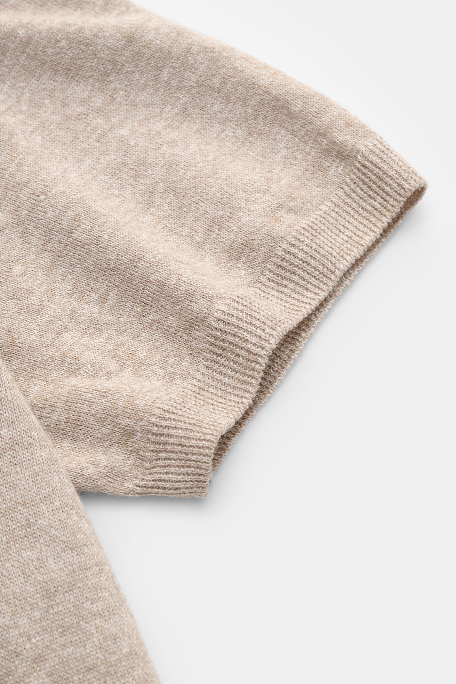 Close-up, top-down view of the sleeve of a Fioroni Short sleeve knit polo beige mottled showing fine, airy linen and cotton blend knit with ribbed bands.

Summery luxury: This short-sleeved knit polo by FIORONI embodies the finest Italian knitwear arti