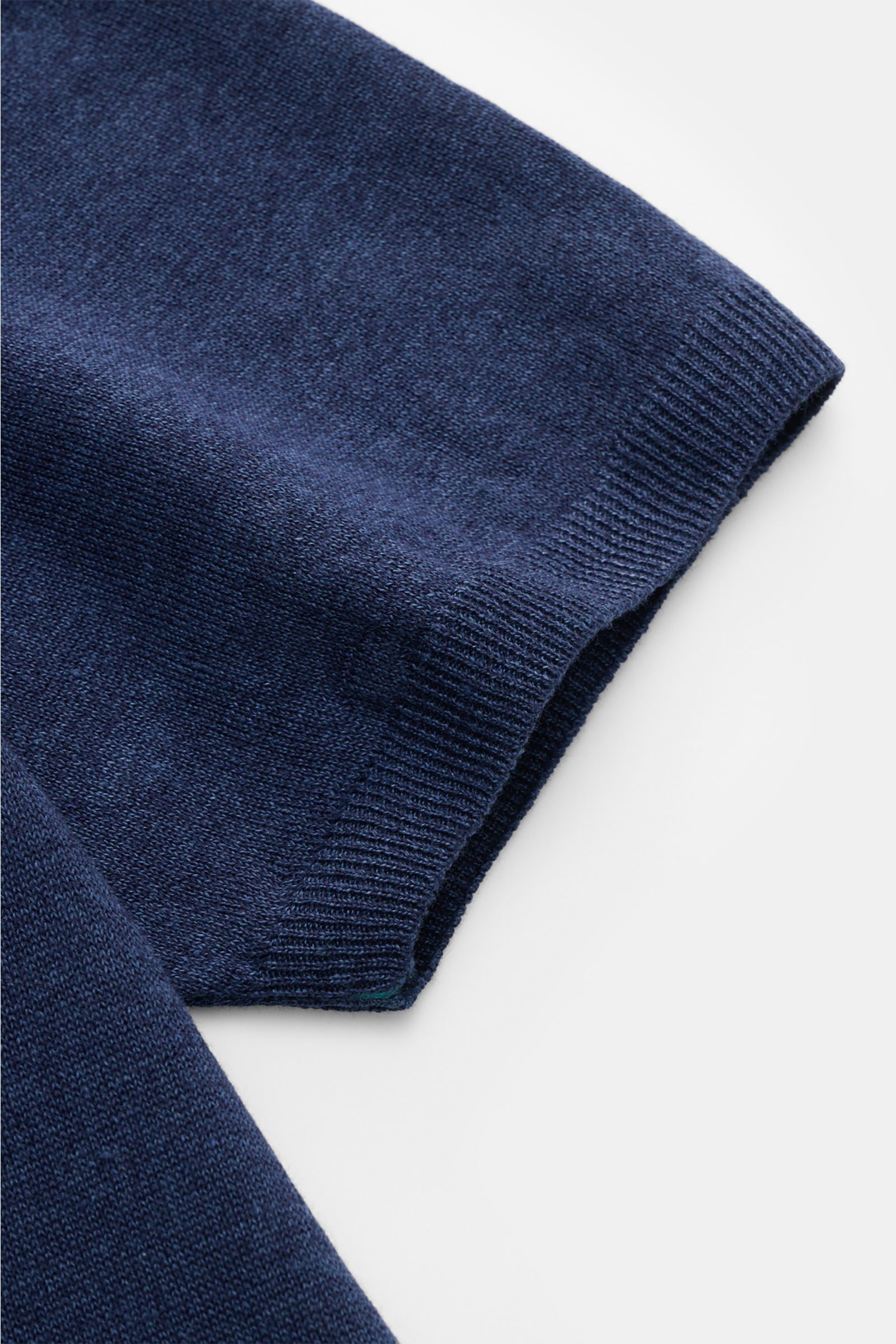 Close-up detail of the navy sleeve of the Fioroni Short sleeve knit polo shirt navy, photographed from a top-down angle, showing the fine, airy knit and flexible ribbed bands. 

Summery luxury: This short-sleeved knit polo by FIORONI embodies the fines