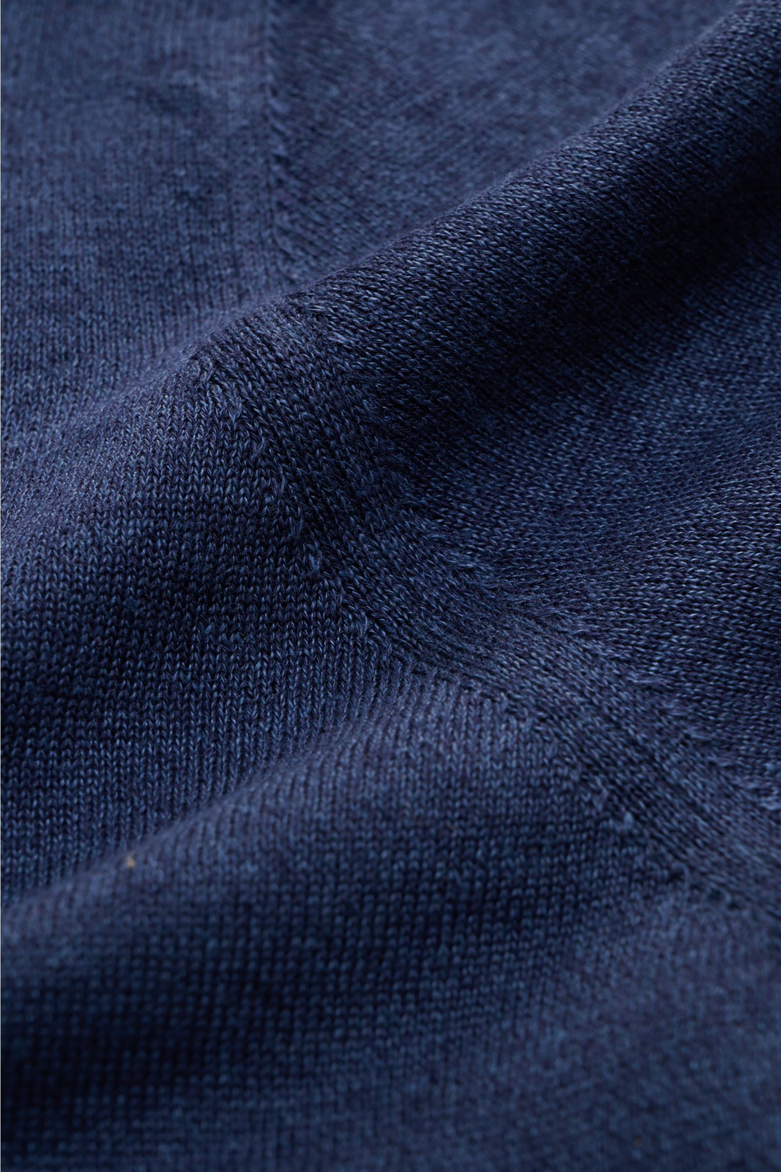 Close-up of navy knit fabric showing fine, airy texture and stitching detail from a top-down perspective, highlighting the Fioroni Short sleeve knit polo shirt navy. Summery luxury: This short-sleeved knit polo by FIORONI embodies the finest Italian knitw