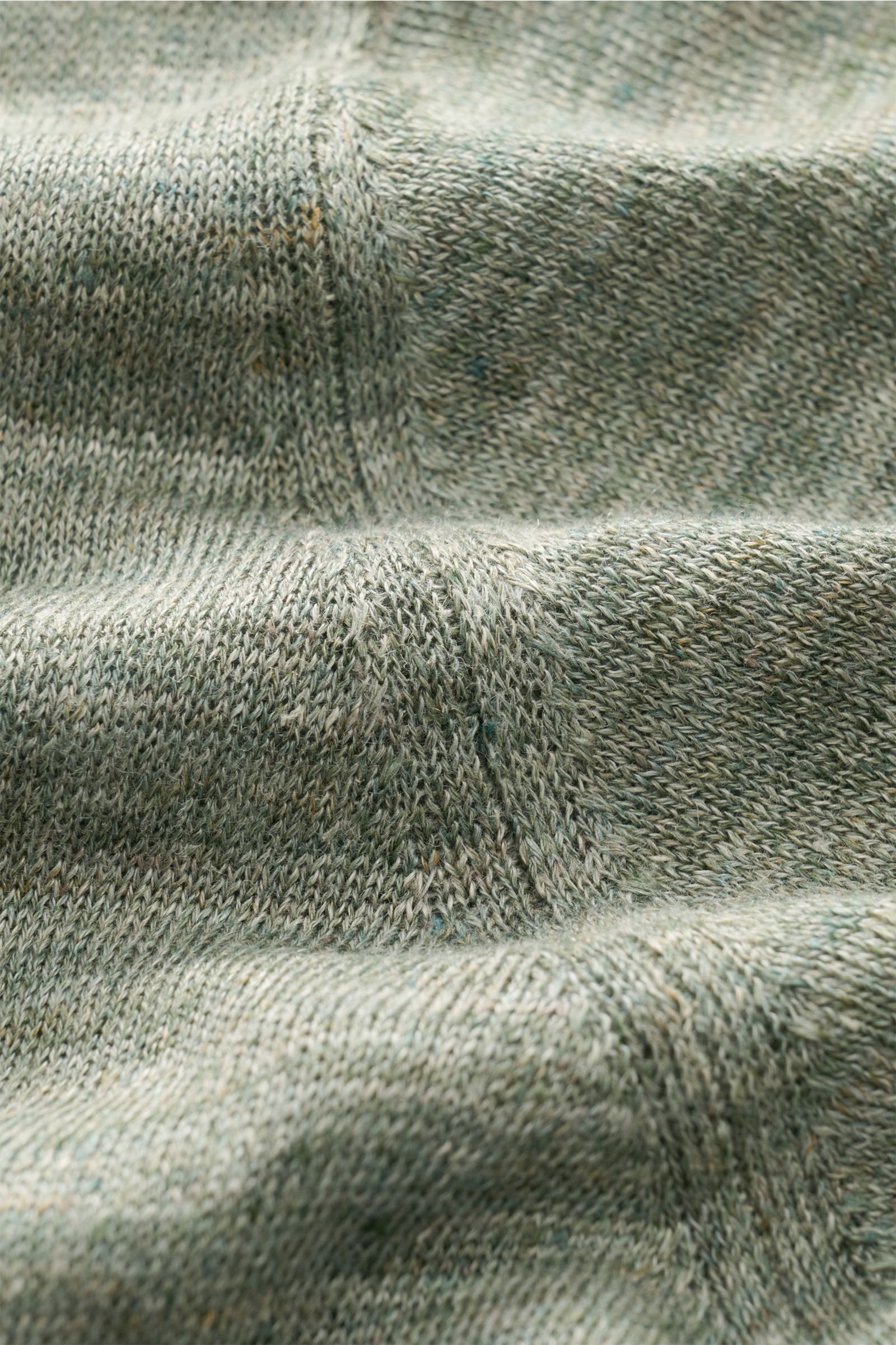 Close-up front view of Fioroni Linen short sleeve knit polo dark green/beige mottled fabric texture, showcasing fine, airy pure linen knit.

Summery lightness by FIORINI: This short sleeve knit polo embodies the best Italian quality and is made of pure