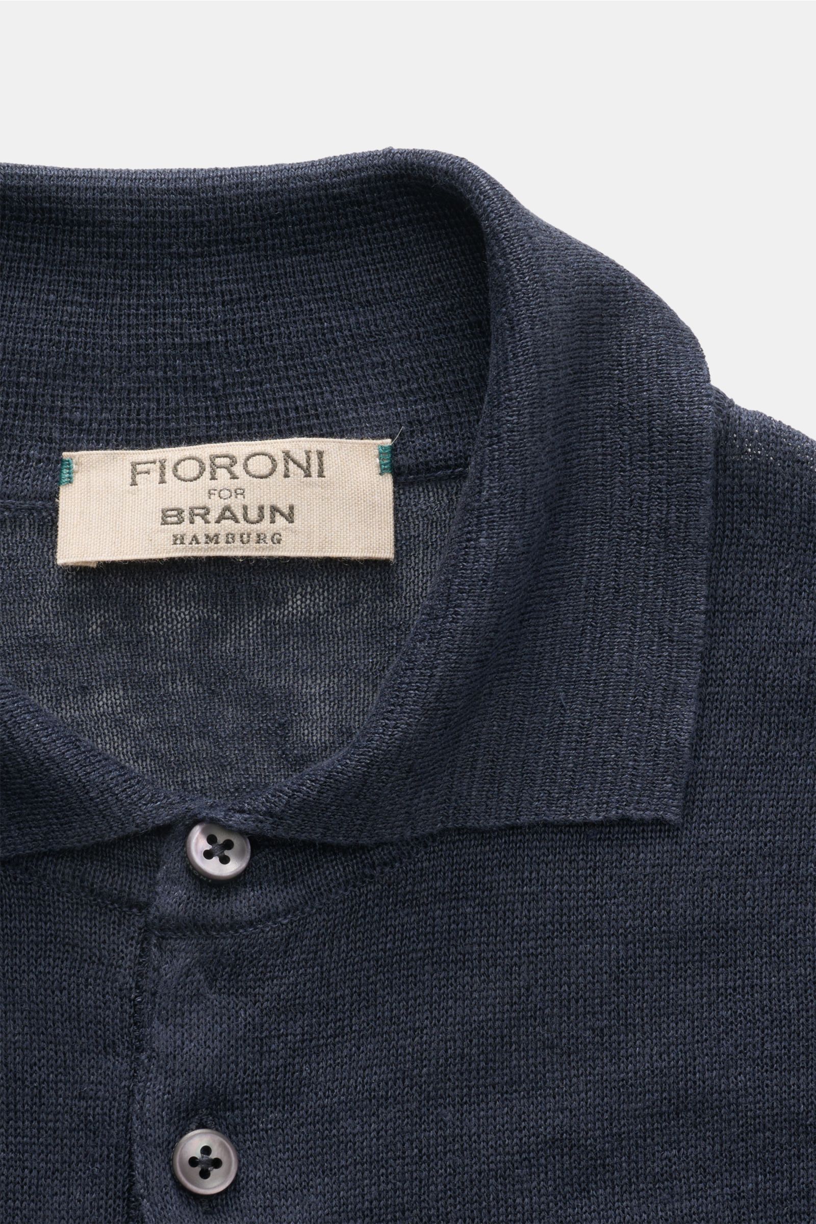 Close-up front view of the Fioroni Linen short sleeve knit polo navy mottled, showing dress-shirt collar and two buttons on fine, airy knit fabric.

Description: Summery lightness by FIORINI: This short sleeve knit polo embodies the best Italian qualit