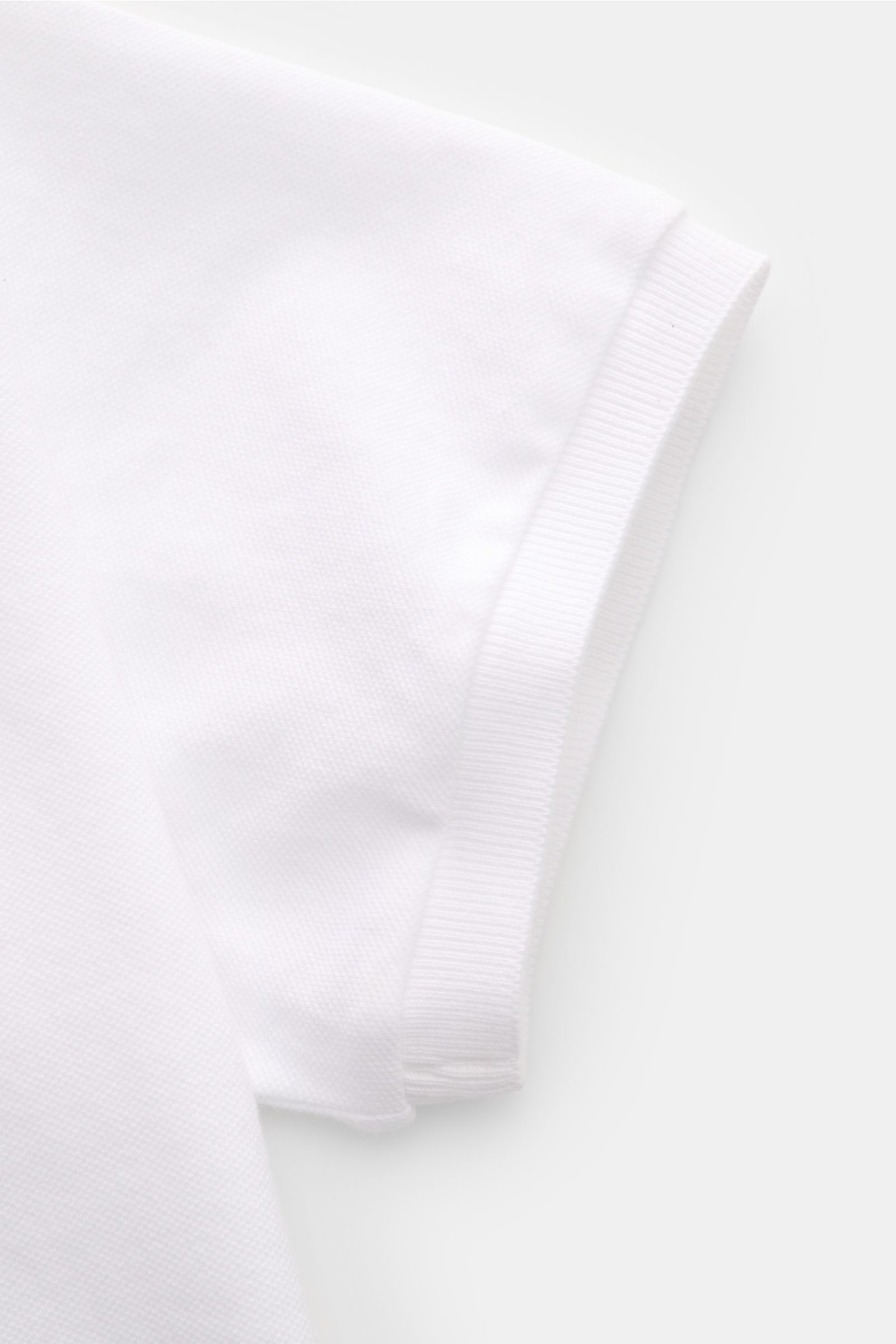 Nahaufnahme des weißen Fedeli Poloshirts 'North' aus Baumwoll-Piqué, Detailansicht des kurzen Ärmels mit weichem Griff, Slim Fit, garment dyed.