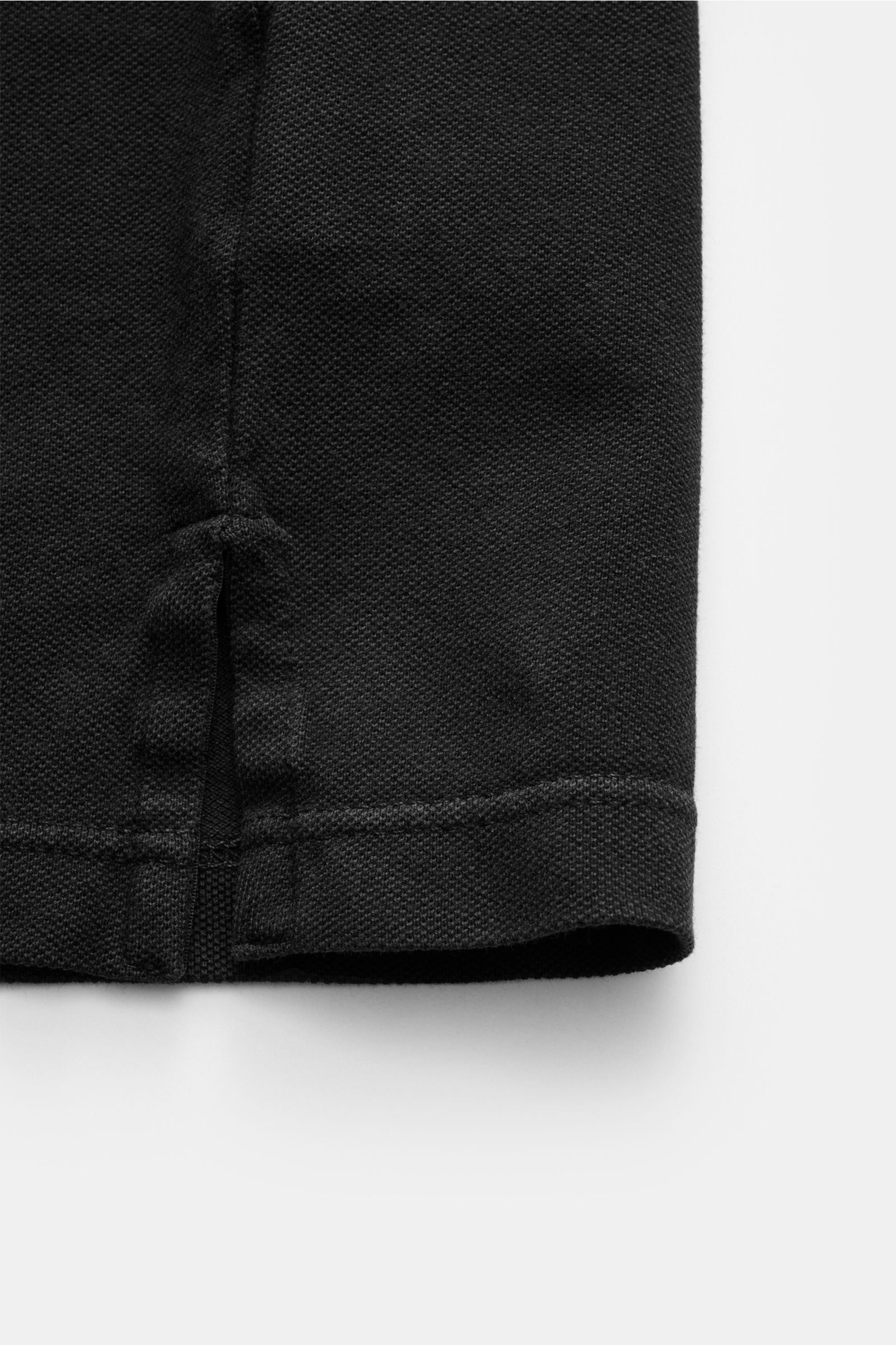 Fedeli Poloshirt 'North' schwarz, Detailansicht Saum mit seitlichem Schlitz, Piqué-Baumwolle, garment dyed, Slim Fit, hinten länger.