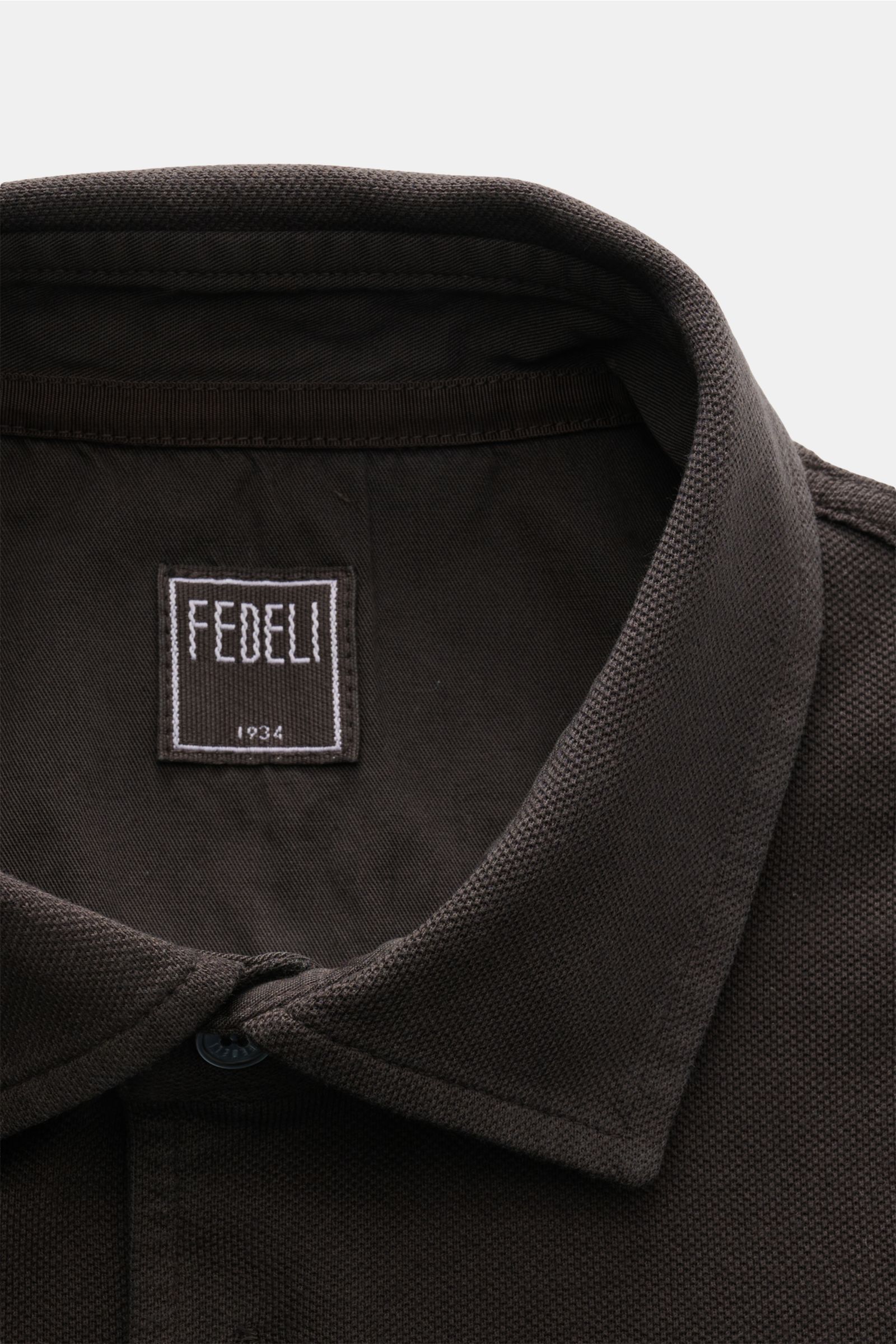 Fedeli Polo shirt 'North' dark brown shown from a close-up top front view, highlighting the collar and label in pure piqué cotton. Quiet luxury: The clean polo shirt 'North' in high-quality cotton piqué by FEDELI doesn’t feature any logos and is dyed in a