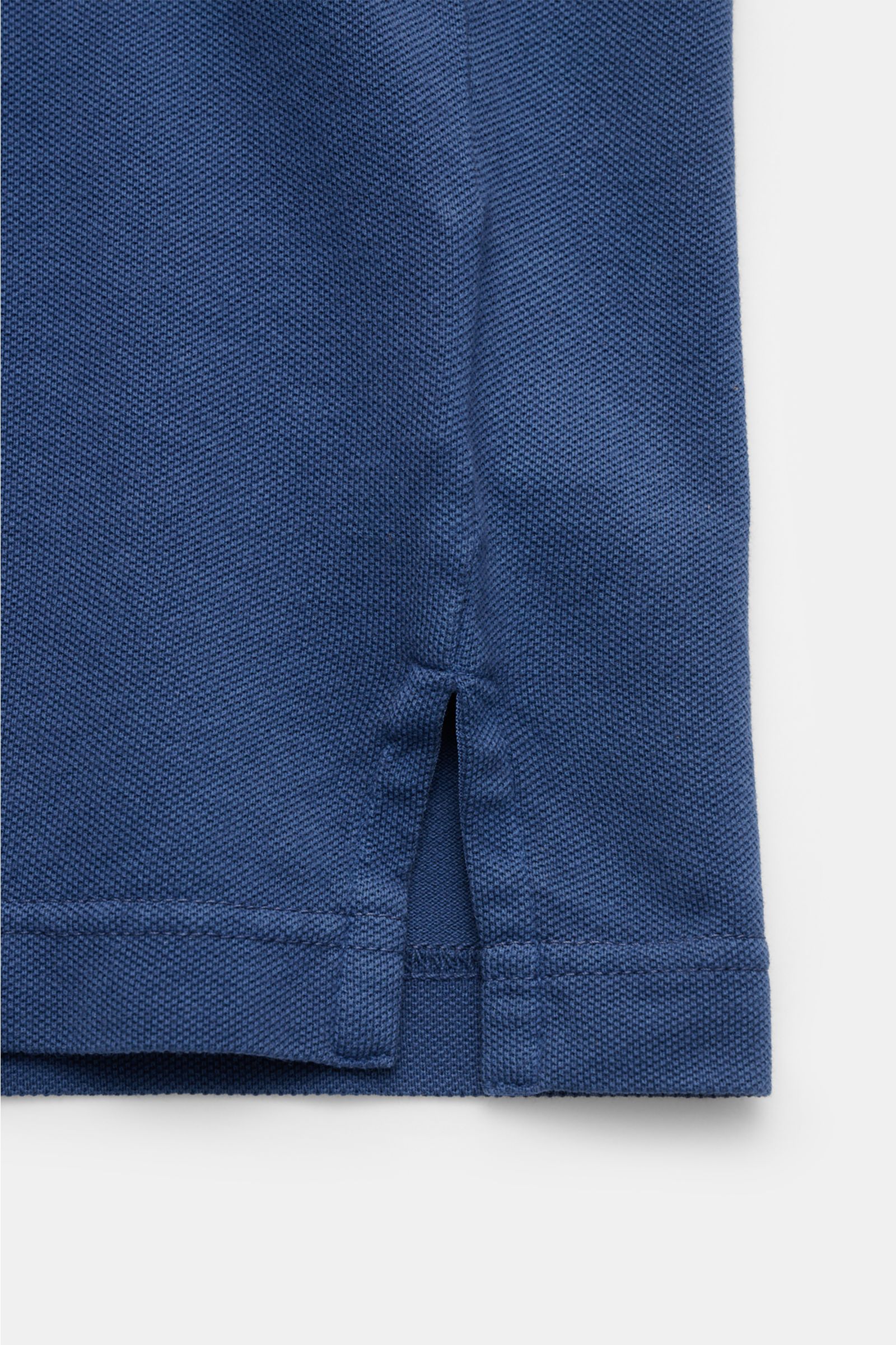 Close-up side hem detail of the Fedeli Poloshirt 'North' dunkelblau, showing the textured cotton piqué fabric, side slit, and stitching from a flat lay perspective.

Quiet Luxury: Das cleane Poloshirt 'North' aus hochwertigem Baumwoll-Piqué von FEDELI 