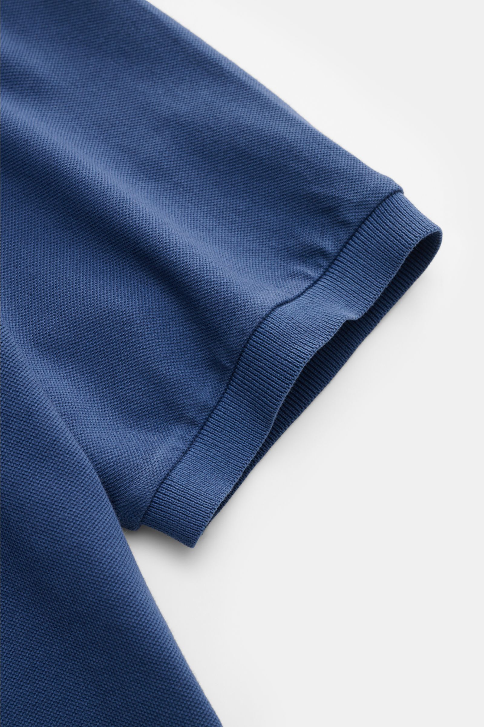 Fedeli Poloshirt 'North' dunkelblau sleeve close-up from above showing cotton piqué texture, ribbed cuff, and clean finish. Quiet Luxury: Das cleane Poloshirt 'North' aus hochwertigem Baumwoll-Piqué von FEDELI kommt ganz ohne Logos aus und wurde im garmen