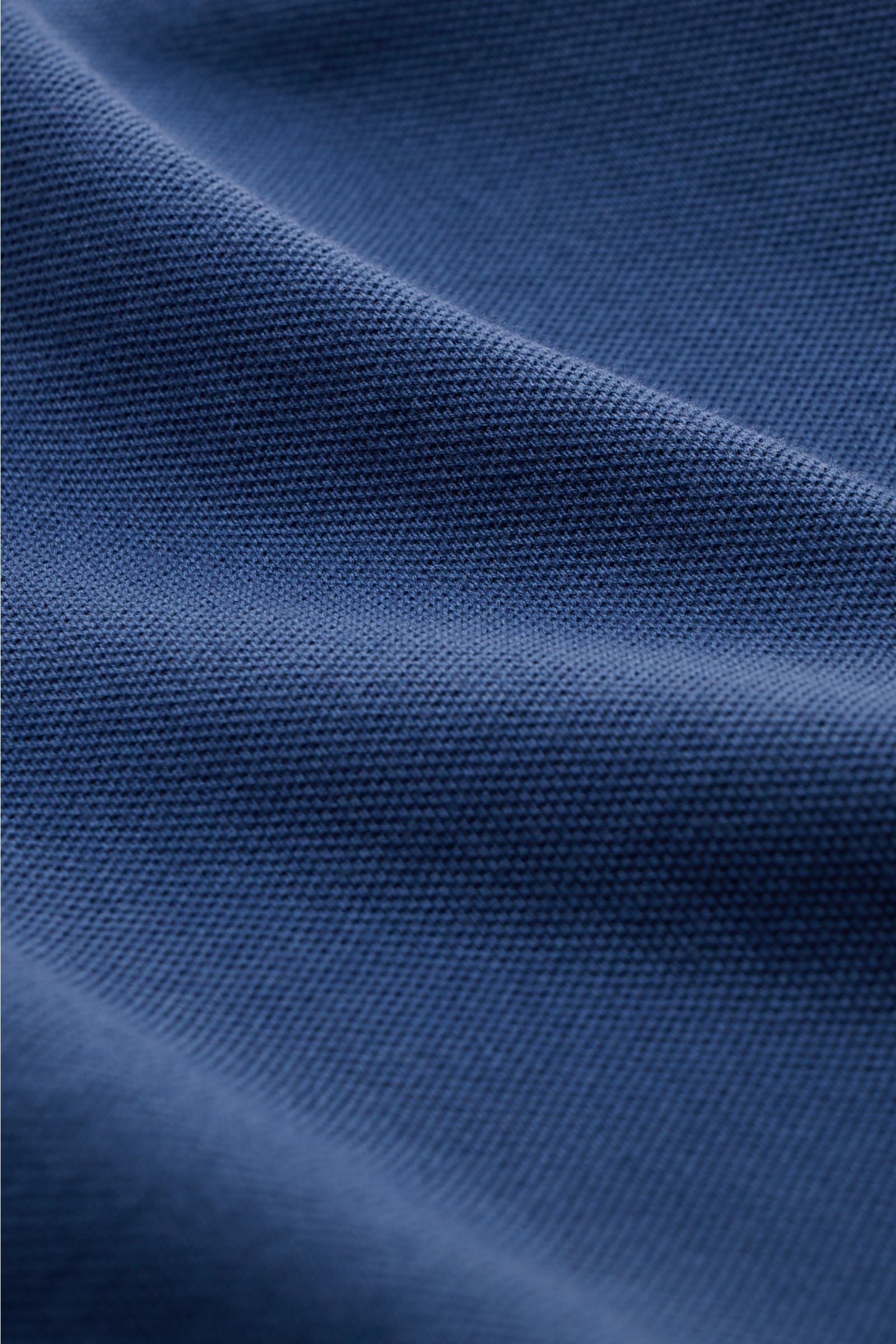 Close-up front view of the fabric texture of Fedeli Poloshirt 'North' dunkelblau, a slim fit garment dyed pure cotton piqué with soft feel.

Description: Quiet Luxury: Das cleane Poloshirt 'North' aus hochwertigem Baumwoll-Piqué von FEDELI kommt ganz o