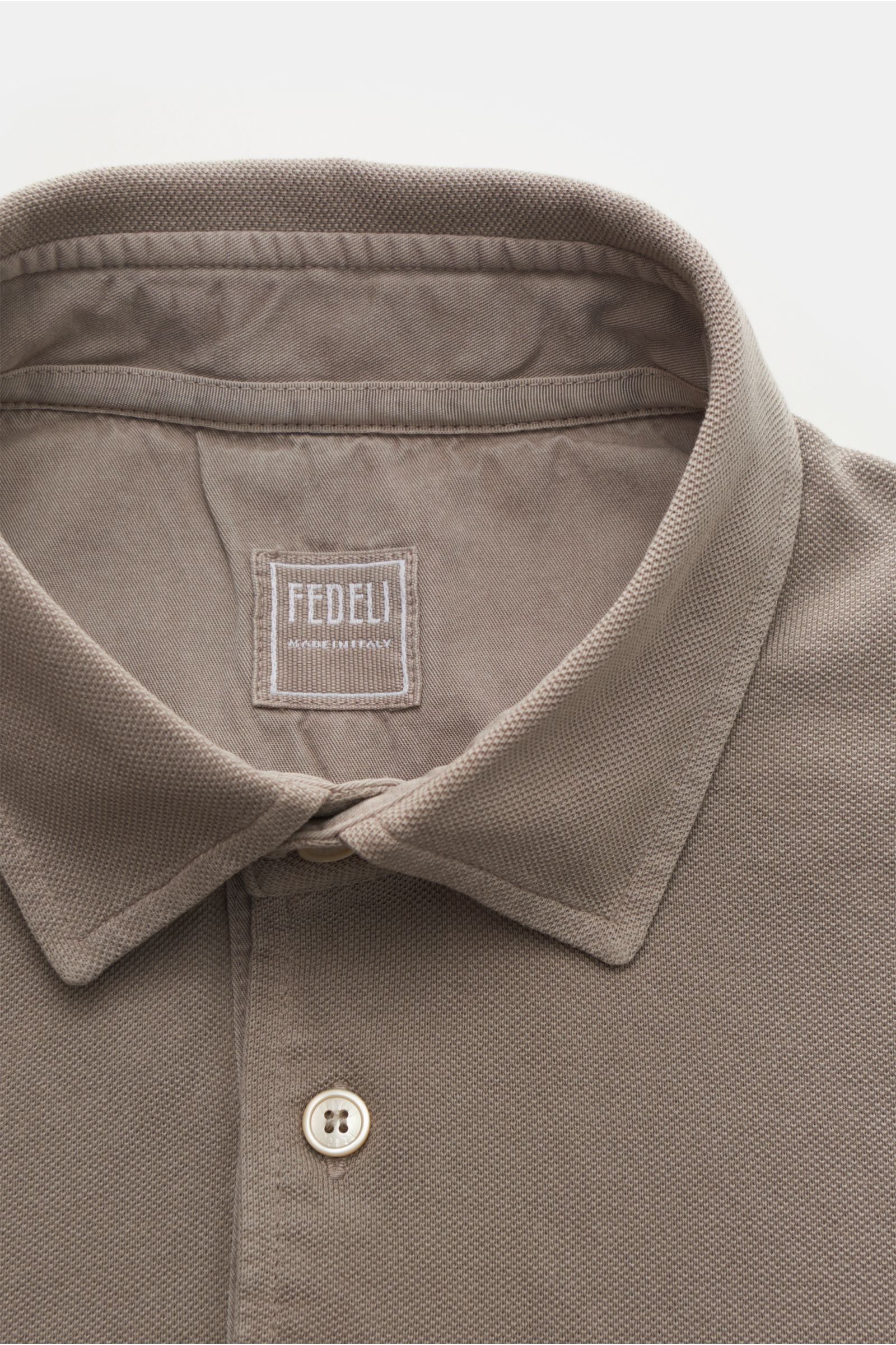 Fedeli Poloshirt 'North' taupe, Nahaufnahme von oben, Baumwoll-Piqué, slim fit, garment dyed, drei Perlmuttknöpfe, typischer Polokragen, seitliche Saumschlitze.