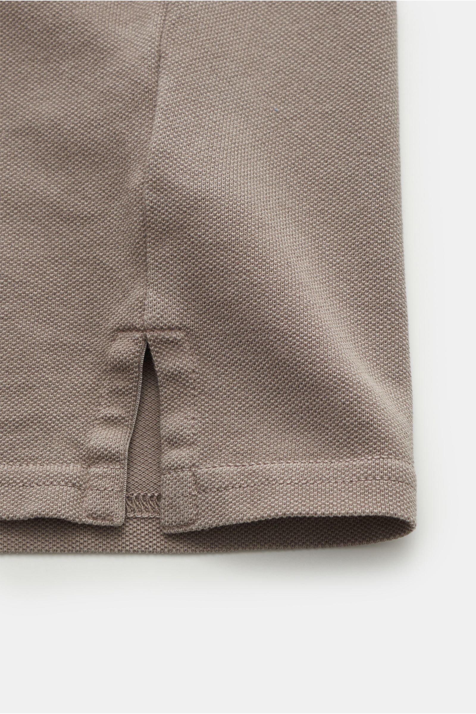 Nahaufnahme der seitlichen Saumschlitze des Fedeli Poloshirts 'North' taupe aus weichem, garment dyed Baumwoll-Piqué, Slim Fit, textile Struktur sichtbar.