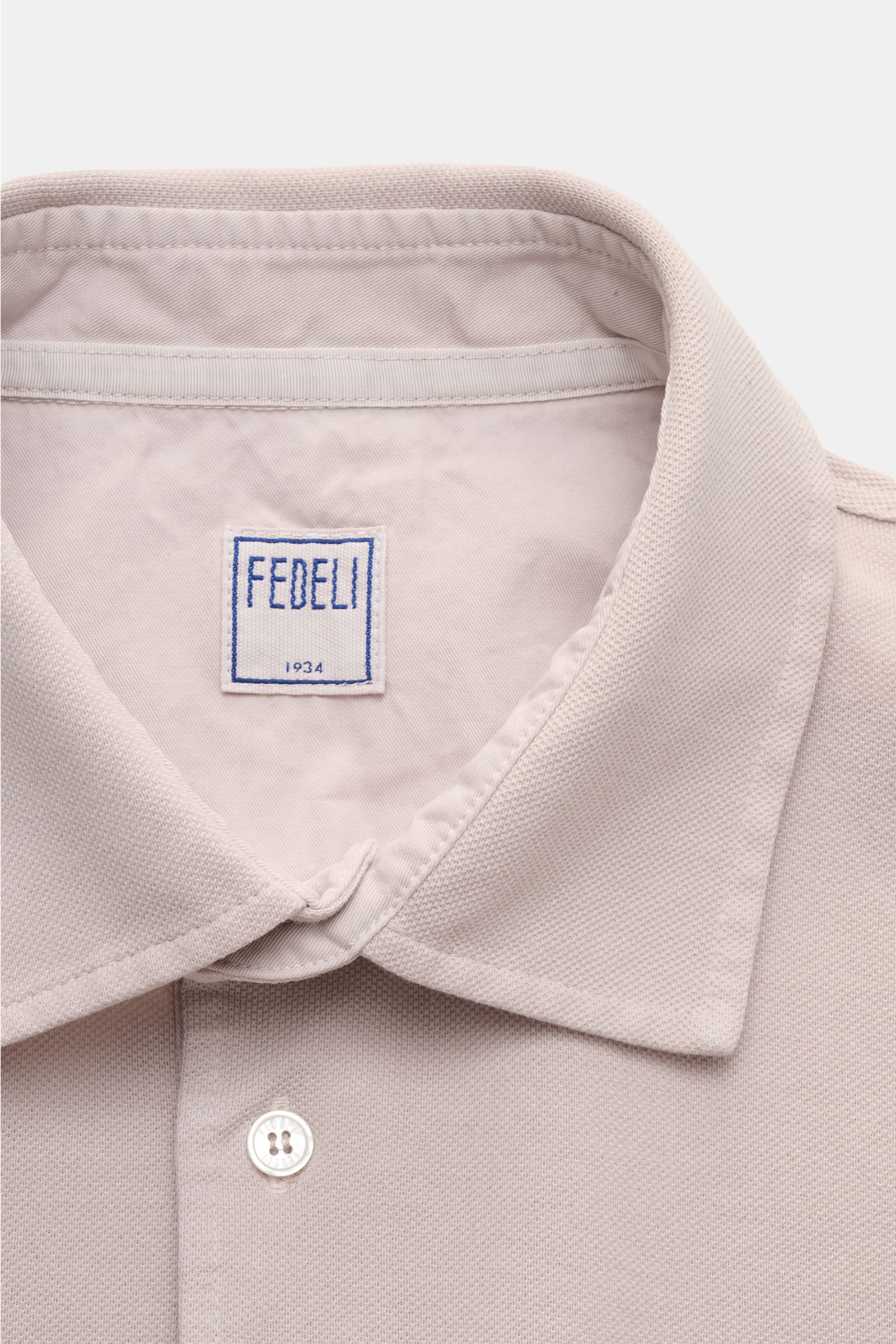 Fedeli Poloshirt 'North' beige close-up from above showing clean collar, mother-of-pearl button, and soft cotton piqué fabric.  
Quiet Luxury: Das cleane Poloshirt 'North' aus hochwertigem Baumwoll-Piqué von FEDELI kommt ganz ohne Logos aus und wurde i