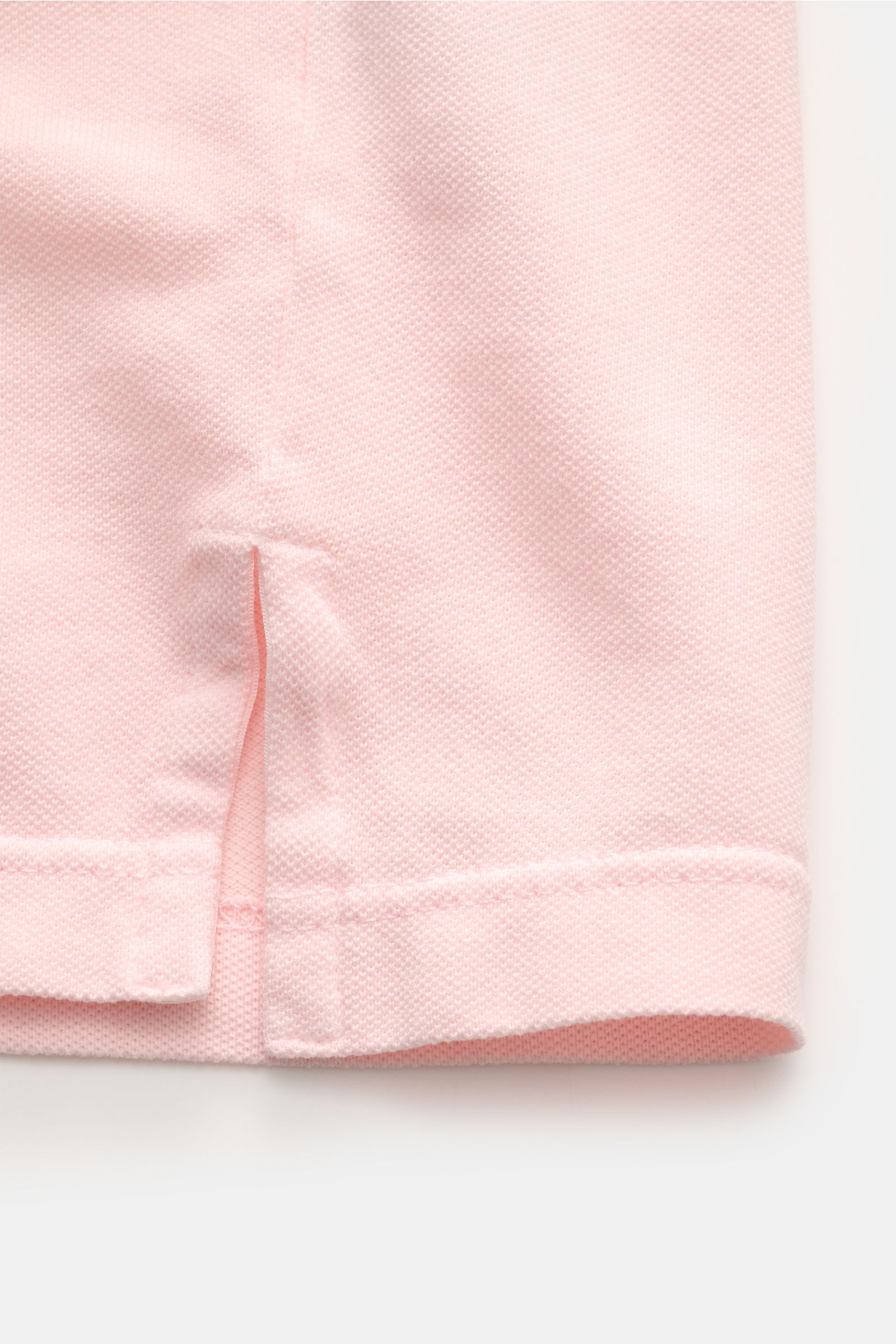 Nahaufnahme des seitlichen Saums mit Saumschlitz des roséfarbenen Fedeli Poloshirts 'North' aus Baumwoll-Piqué, garment dyed, Slim Fit.