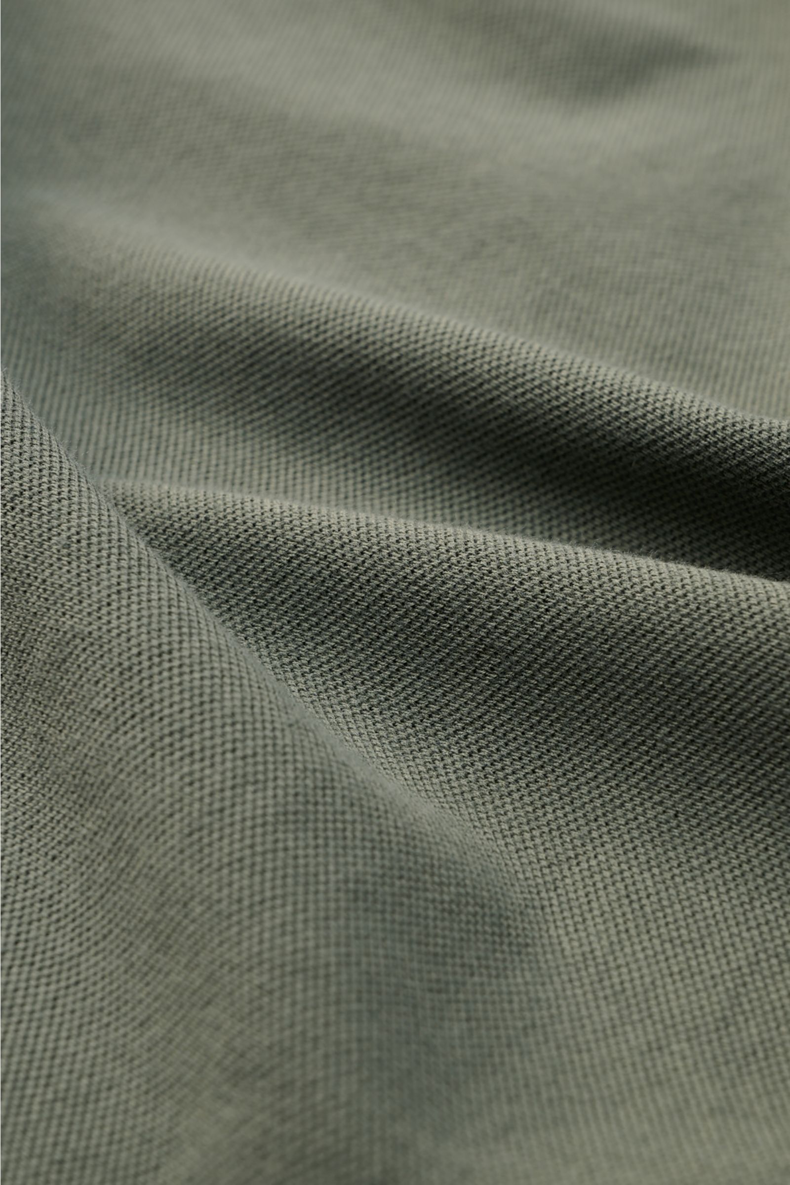 Close-up view of the fabric texture of the Fedeli Poloshirt 'North' graugrün, showing soft, grey-green pure cotton piqué knit. Quiet Luxury: Das cleane Poloshirt 'North' aus hochwertigem Baumwoll-Piqué von FEDELI kommt ganz ohne Logos aus und wurde im gar