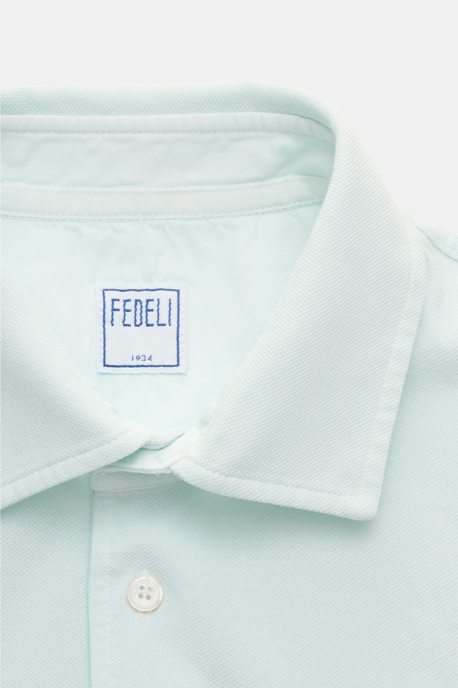 Close-up front view of the Fedeli Poloshirt 'North' mintgrün showing the slim fit, typical polo collar, and pearl button placket.

Quiet Luxury: Das cleane Poloshirt 'North' aus hochwertigem Baumwoll-Piqué von FEDELI kommt ganz ohne Logos aus und wurde