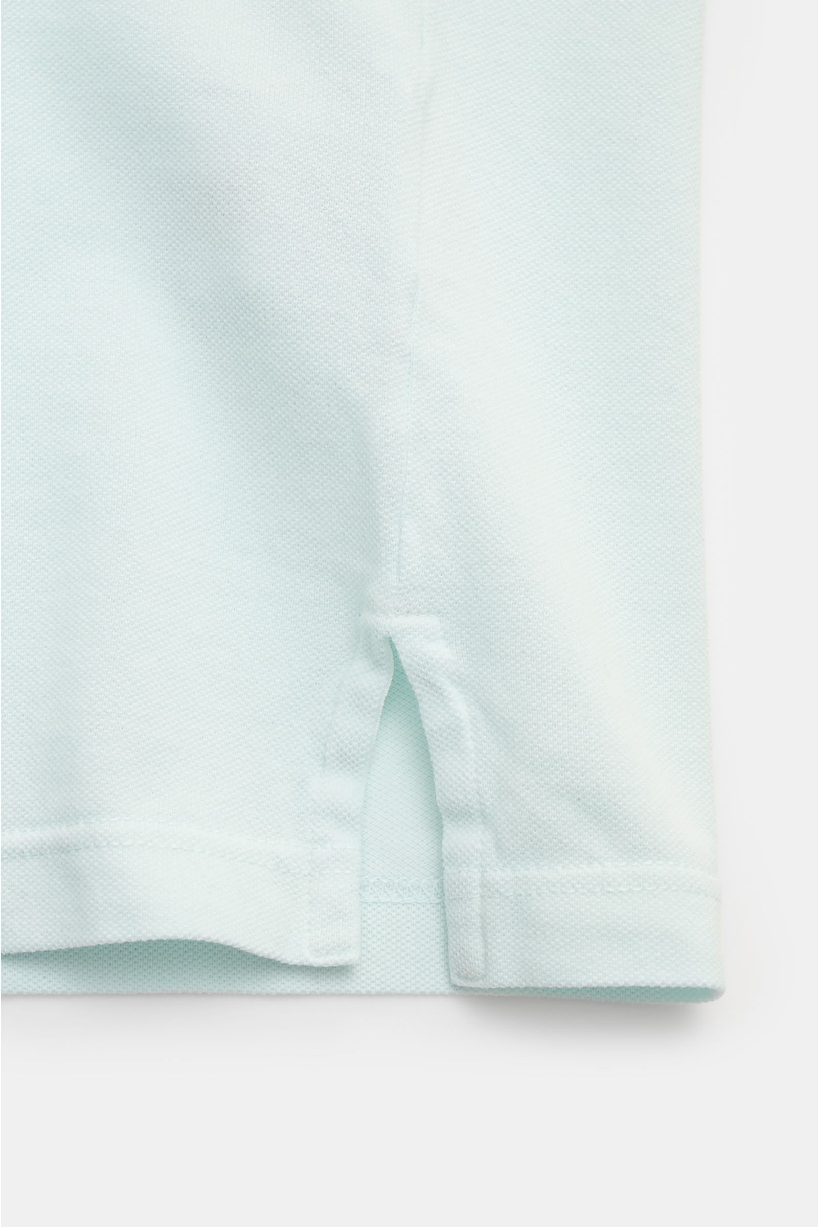 Close-up side hem view of the Fedeli Poloshirt 'North' mintgrün showing mint green cotton piqué fabric with side slits and clean stitching.

Quiet Luxury: Das cleane Poloshirt 'North' aus hochwertigem Baumwoll-Piqué von FEDELI kommt ganz ohne Logos aus