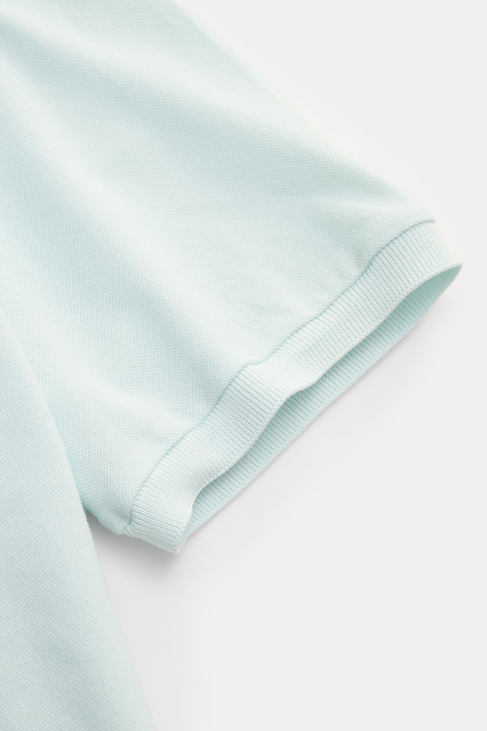 Close-up side view of the sleeve of the Fedeli Poloshirt 'North' mintgrün in soft, garment dyed pure cotton piqué with ribbed cuff. Quiet Luxury: Das cleane Poloshirt 'North' aus hochwertigem Baumwoll-Piqué von FEDELI kommt ganz ohne Logos aus und wurde i