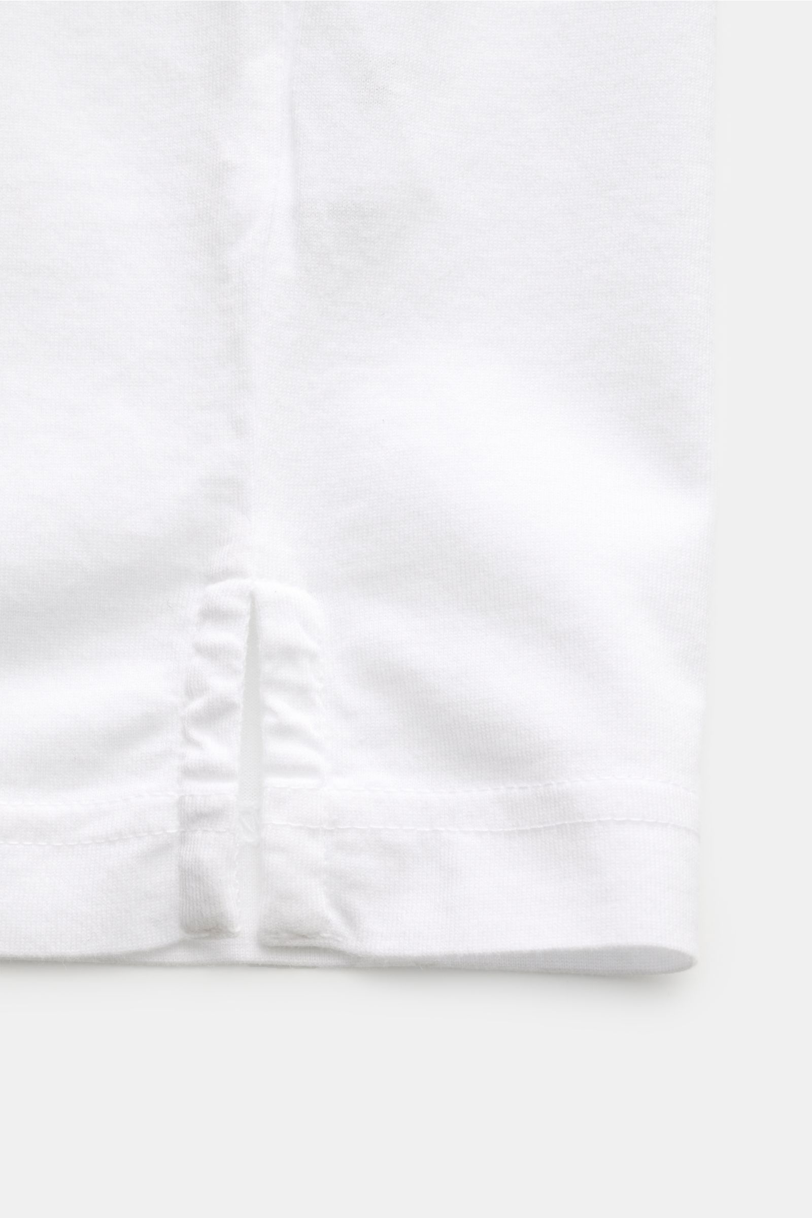 Nahaufnahme des seitlichen Saums mit Saumschlitz des Fedeli Jersey-Poloshirt 'Zero' weiß aus Bio-Baumwolle, Slim Fit, garment dyed.