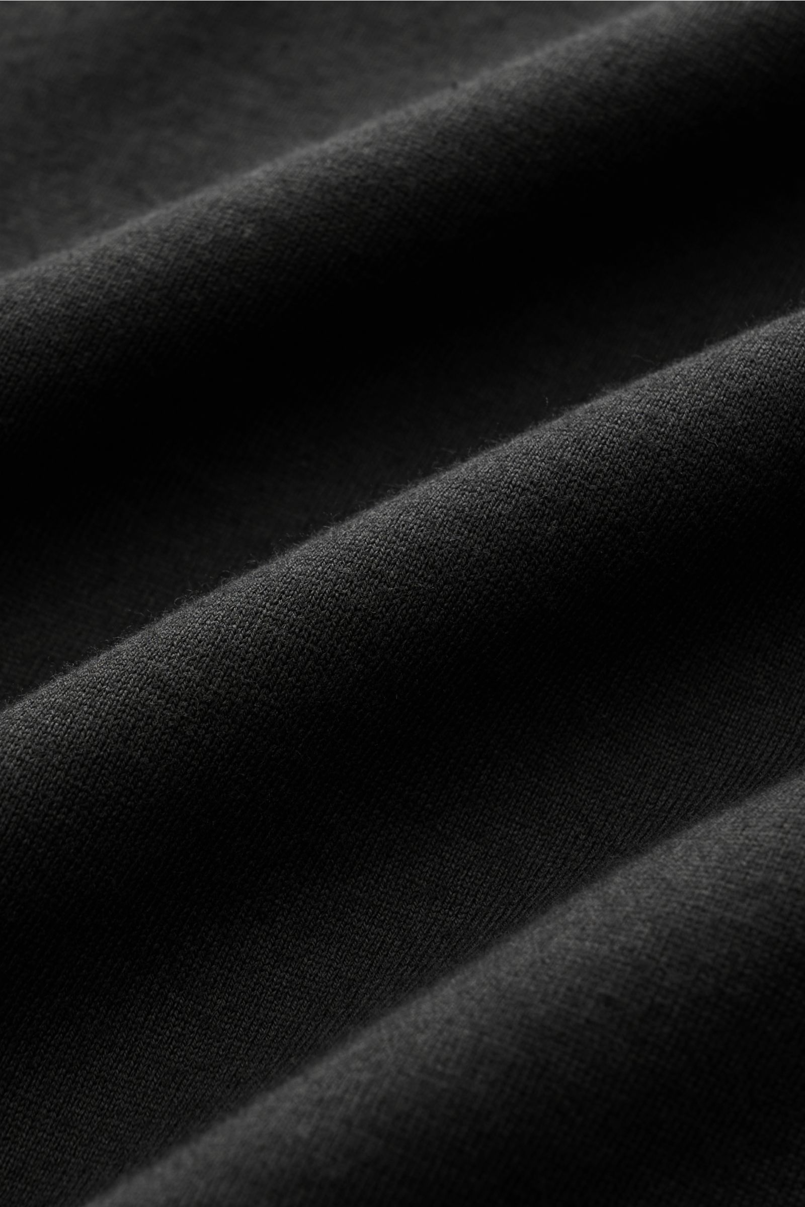 Fedeli Jersey-Poloshirt 'Zero' schwarz, Detailaufnahme des glatten, schwarzen Jerseys aus reiner Bio-Baumwolle mit feiner Struktur, weich und hochwertig.