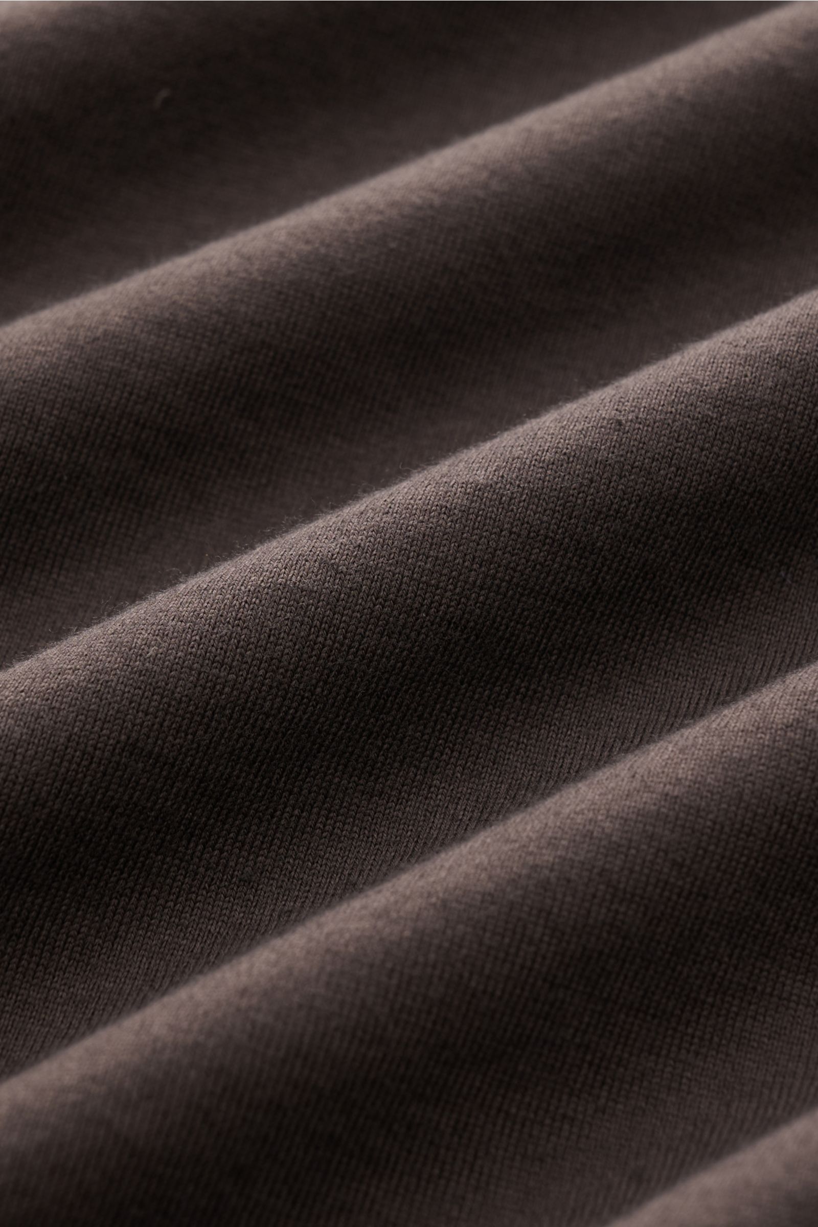 Nahaufnahme des graubraunen Fedeli Jersey-Poloshirts 'Zero' aus Bio-Giza-Baumwolle, textile Struktur und glatter Griff sichtbar.