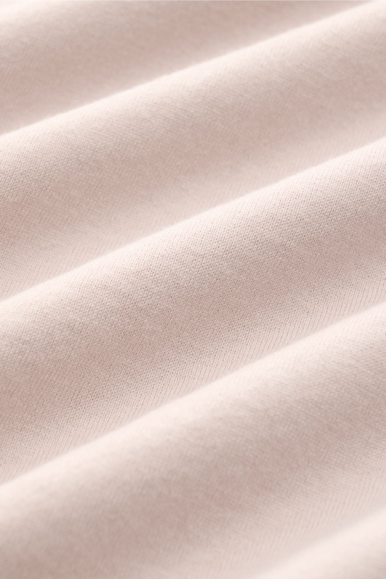 Nahaufnahme des beigen Fedeli Jersey-Poloshirts 'Zero' aus Bio-Baumwolle, mit glattem Griff und feiner Jersey-Struktur, detailreich fotografiert.