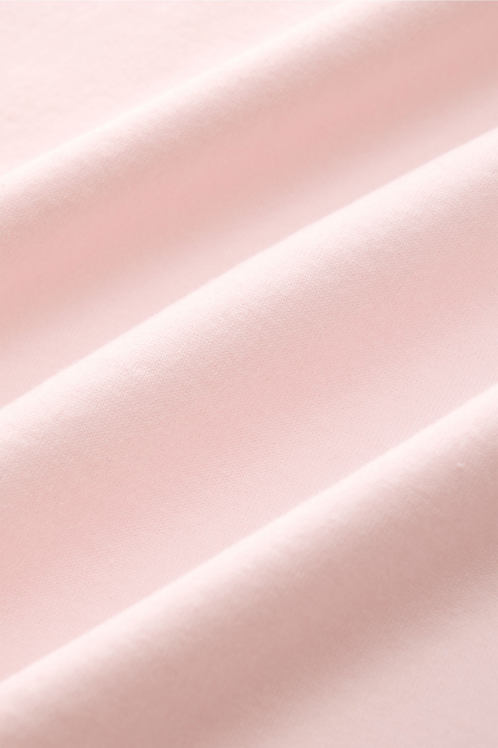 Nahaufnahme des weichen, roséfarbenen Jersey-Stoffs des Fedeli Jersey-Poloshirt 'Zero' aus Bio-Baumwolle mit geschmeidigem Griff.