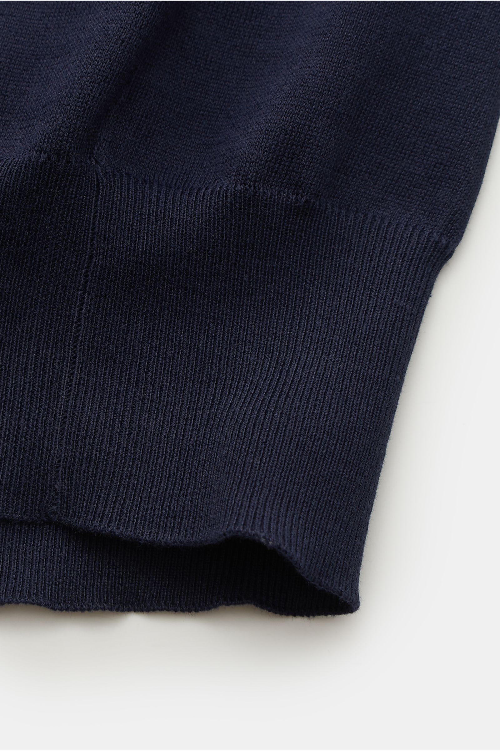 Alt tag (125 characters max):
Close-up of navy ribbed hem on Brunello Cucinelli Short sleeve knit polo shirt navy, shown from a side angle on white background.

Description:
This timeless short-sleeved polo shirt from BRUNELLO CUCINELLI features a ligh