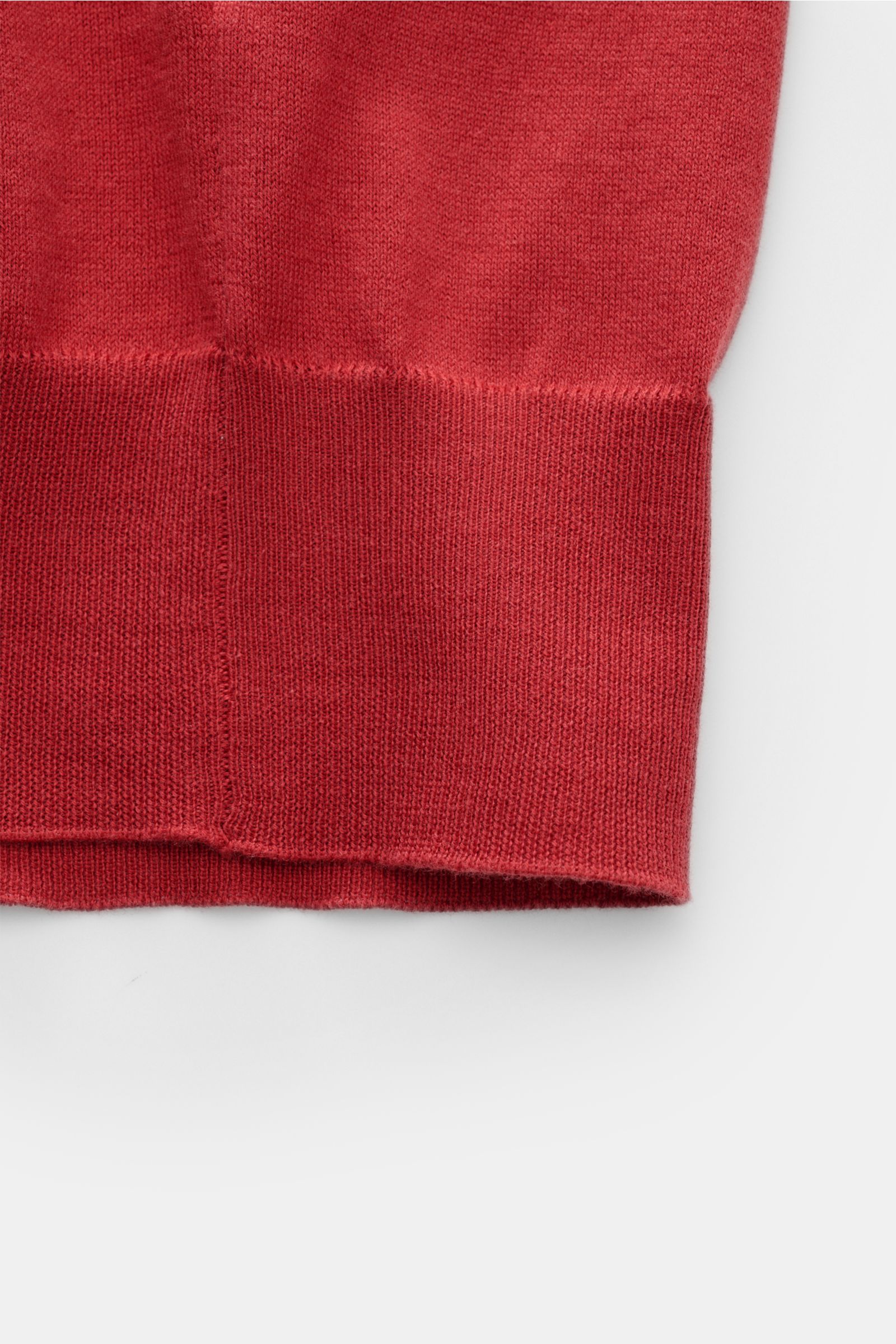 Close-up view of the lower hem and ribbed cuff of the Brunello Cucinelli Kurzarm-Strickpolo rot in red, showing fine knit texture and soft cotton fabric.

Luxuriöse Alltags-Looks profitieren von der leichten Strickqualität dieses zeitlosen Kurzarm-Polo