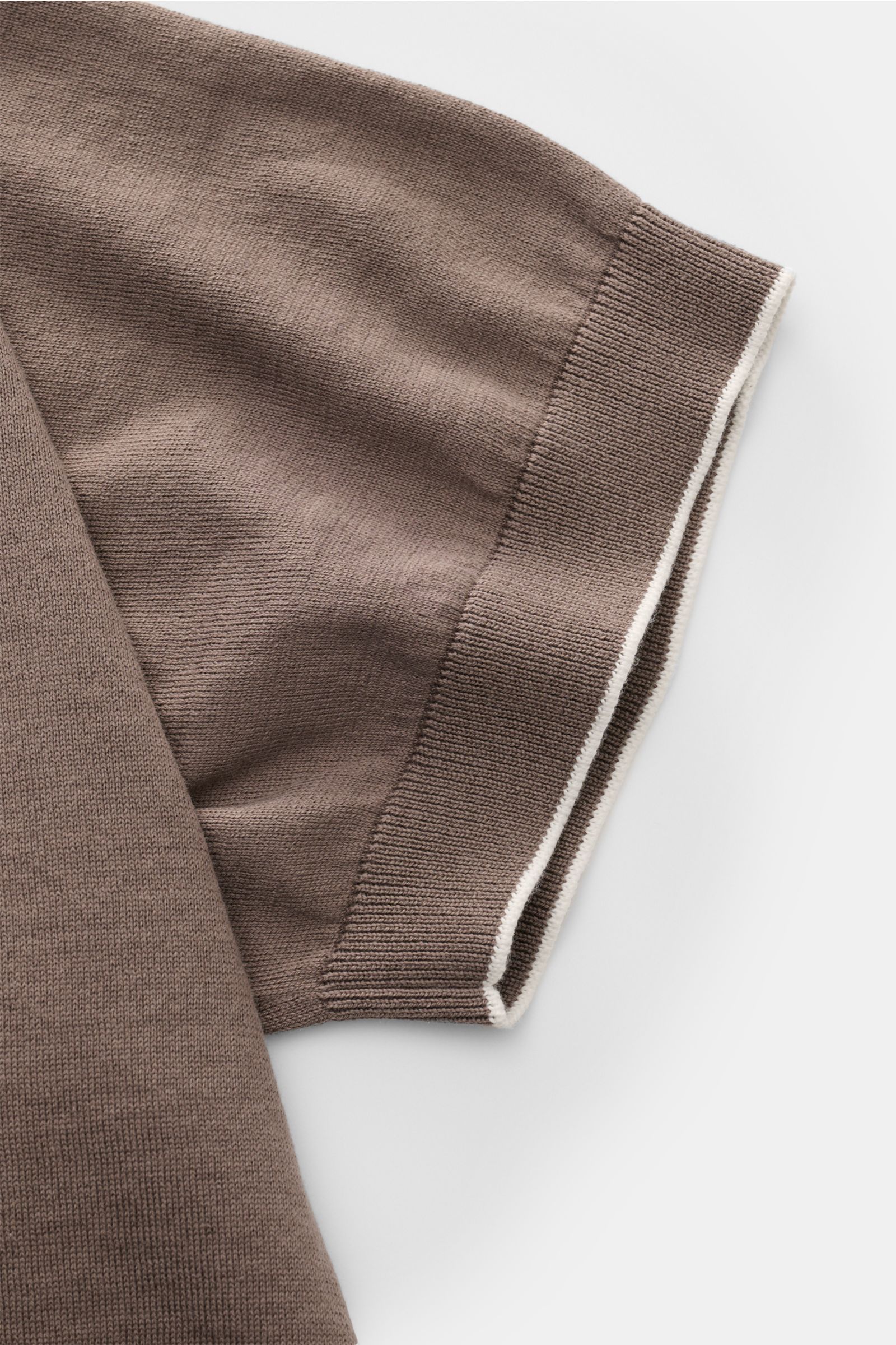 Close-up side view of the sleeve of the Brunello Cucinelli Kurzarm-Strickpolo graubraun, showing fine knit cotton fabric and slim fit. Luxuriöse Alltags-Looks profitieren von der leichten Strickqualität dieses zeitlosen Kurzarm-Poloshirts von BRUNELLO 