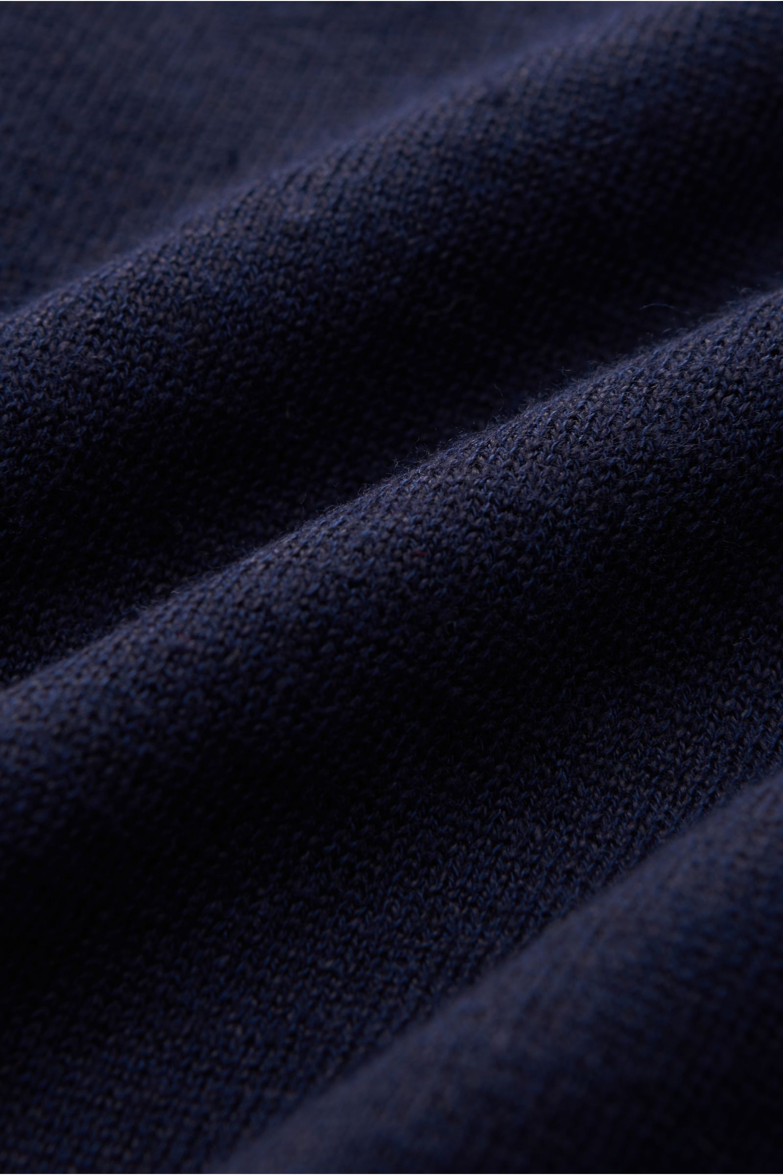 Close-up view of the dark blue fabric texture of the Brunello Cucinelli Kurzarm-Strickpolo dunkelblau, showing fine knit detail.

Mit seinem luftigen Mix aus Leinen und Baumwolle bietet dieses stilvolle Strickpolo von BRUNELLO CUCINELLI ein luxuriös le
