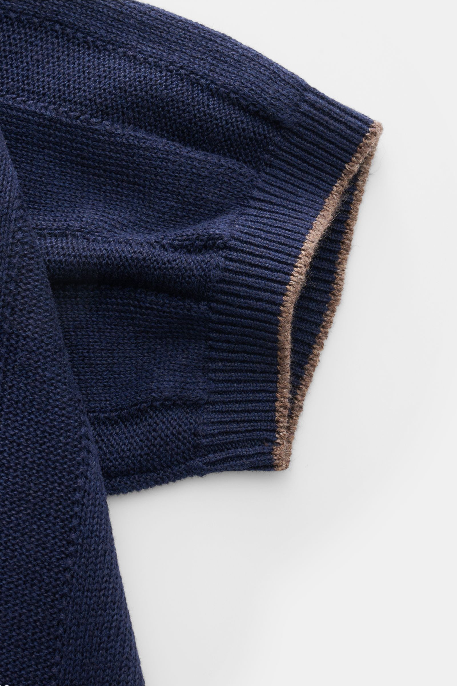 Close-up view of the sleeve of the Brunello Cucinelli Kurzarm-Strickhemd navy, showcasing the mid-fine knit texture with navy and brown contrast edges. Elegantes Highlight in der Frühlings- und Sommersaison: Das luxuriöse Strickhemd von BRUNELLO CUCINELLI