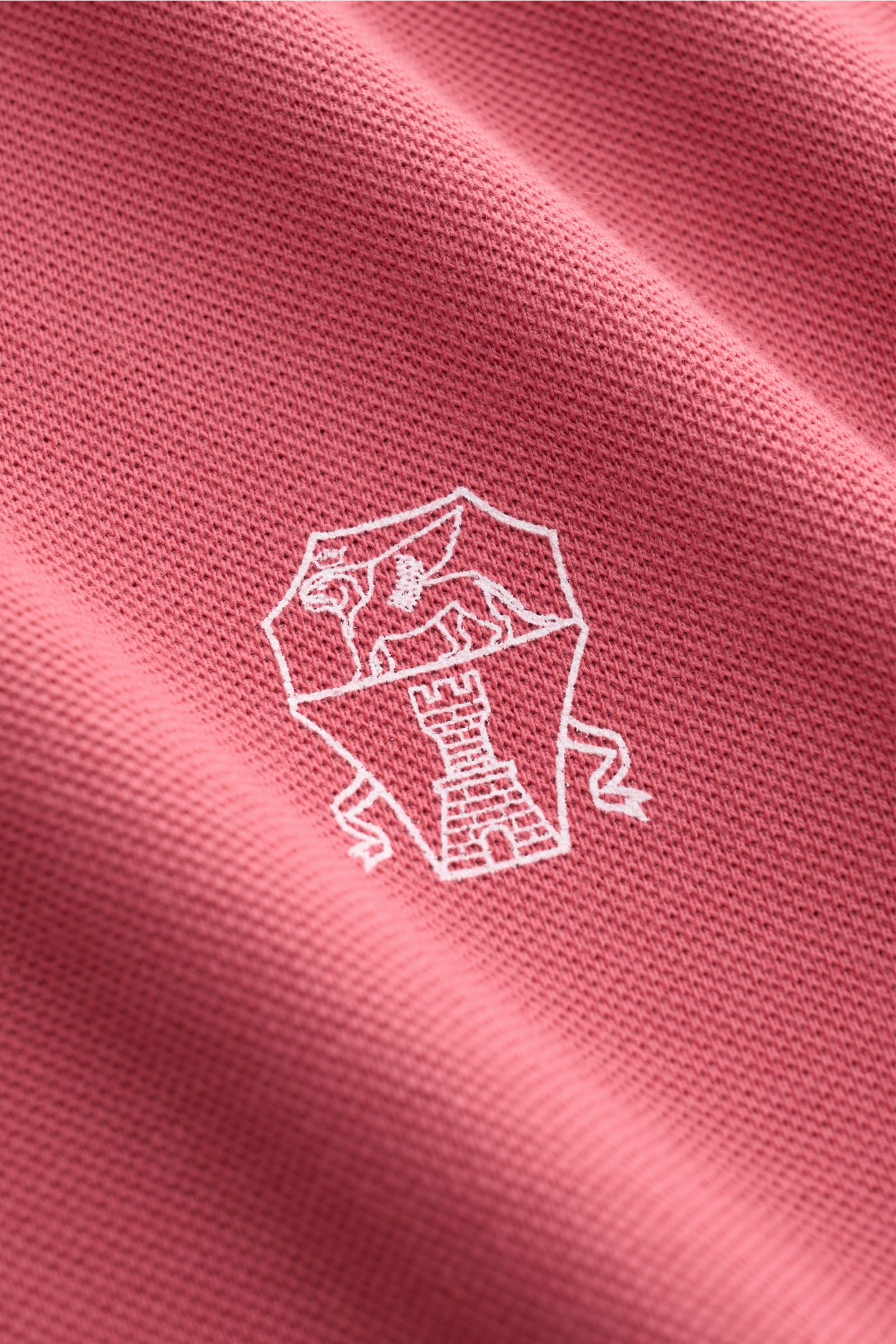 Brunello Cucinelli Poloshirt hellrot aus reiner Baumwolle, Slim Fit, Piqué-Struktur, Nahaufnahme des Logos aus schräger Perspektive.