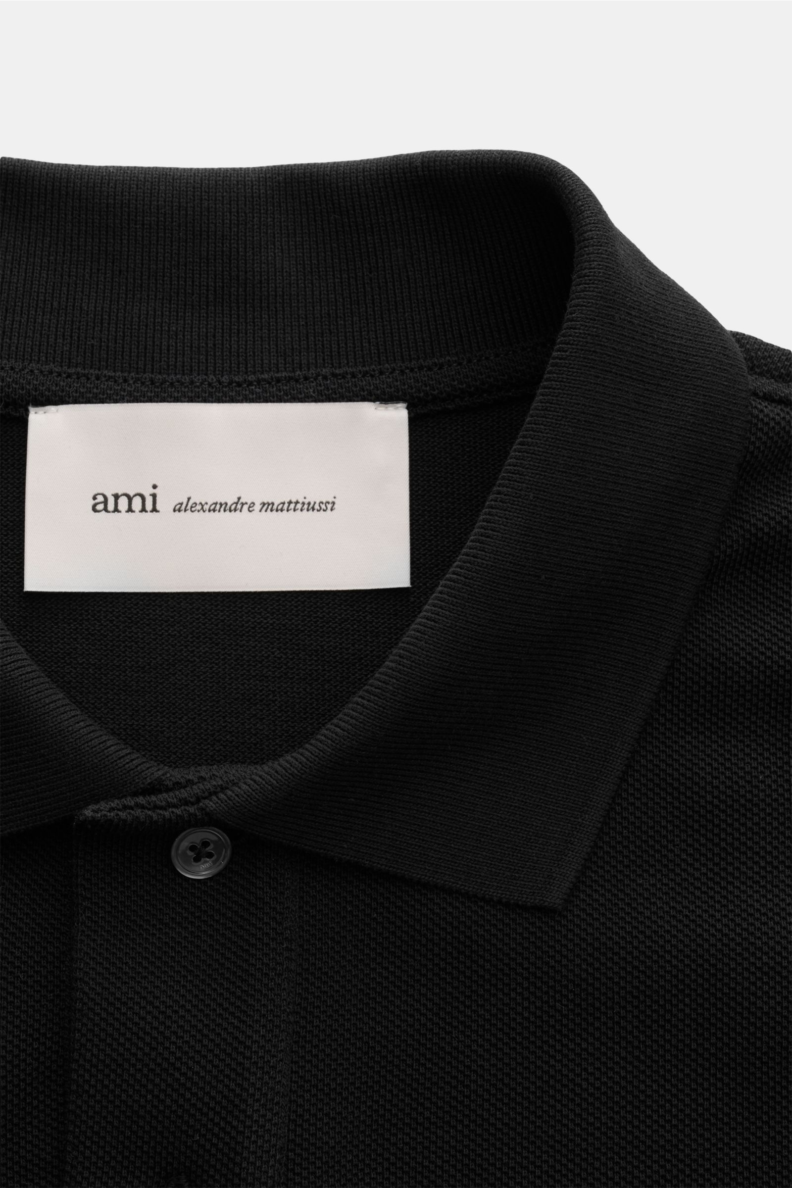 Nahaufnahme des Ami Paris Poloshirts schwarz mit Piqué-Baumwolle, Slim Fit, Polokragen, Zwei-Knopf-Leiste und Logo-Stitching frontal.