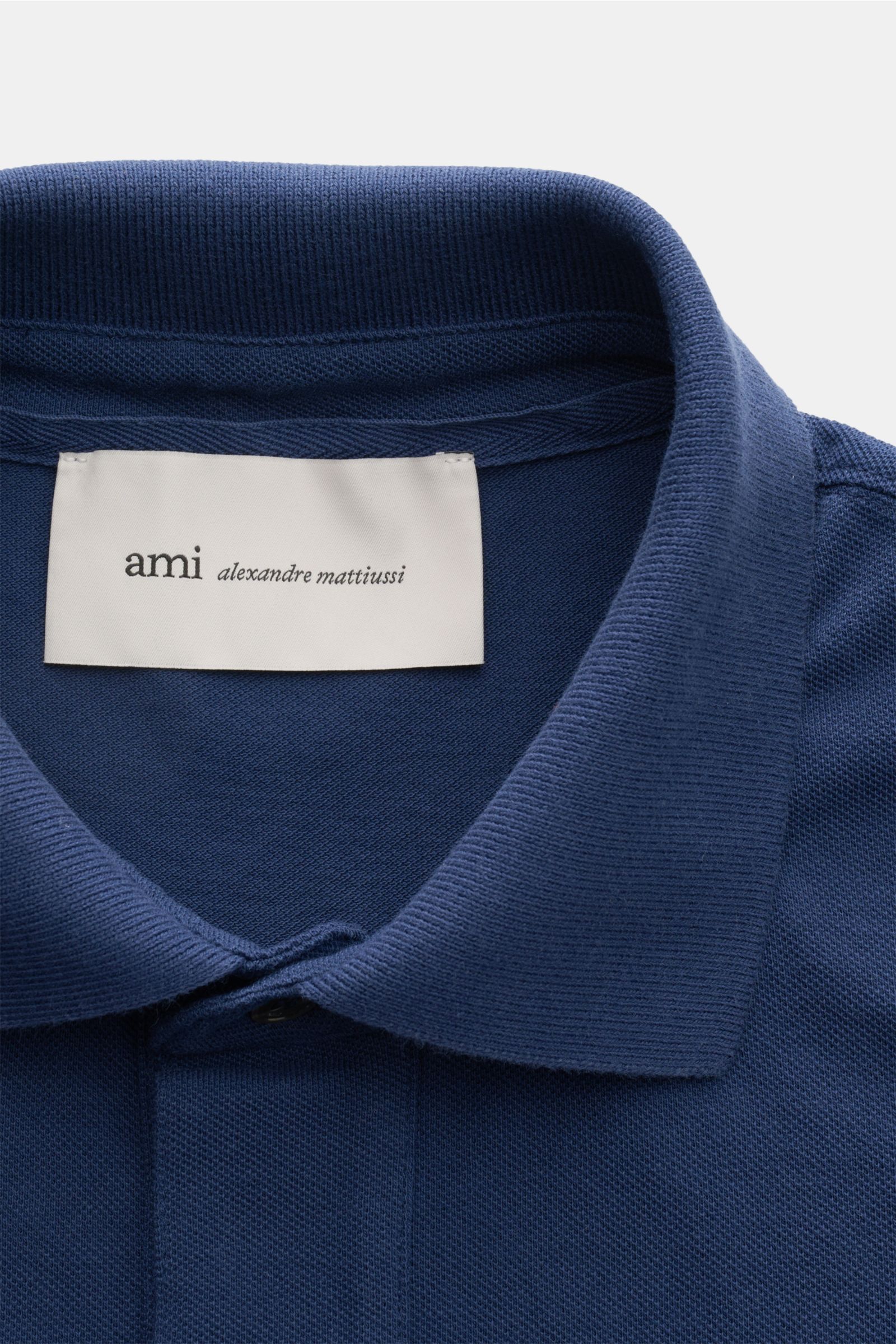 Close-up front view of Ami Paris Poloshirt 'Boxy Fit' dunkelblau showing the classic collar, three-button placket, and fine piqué texture.

Klassiker in moderner Silhouette: Das Poloshirt von AMI PARIS überzeugt mit geradem Schnitt für lässige Frühling